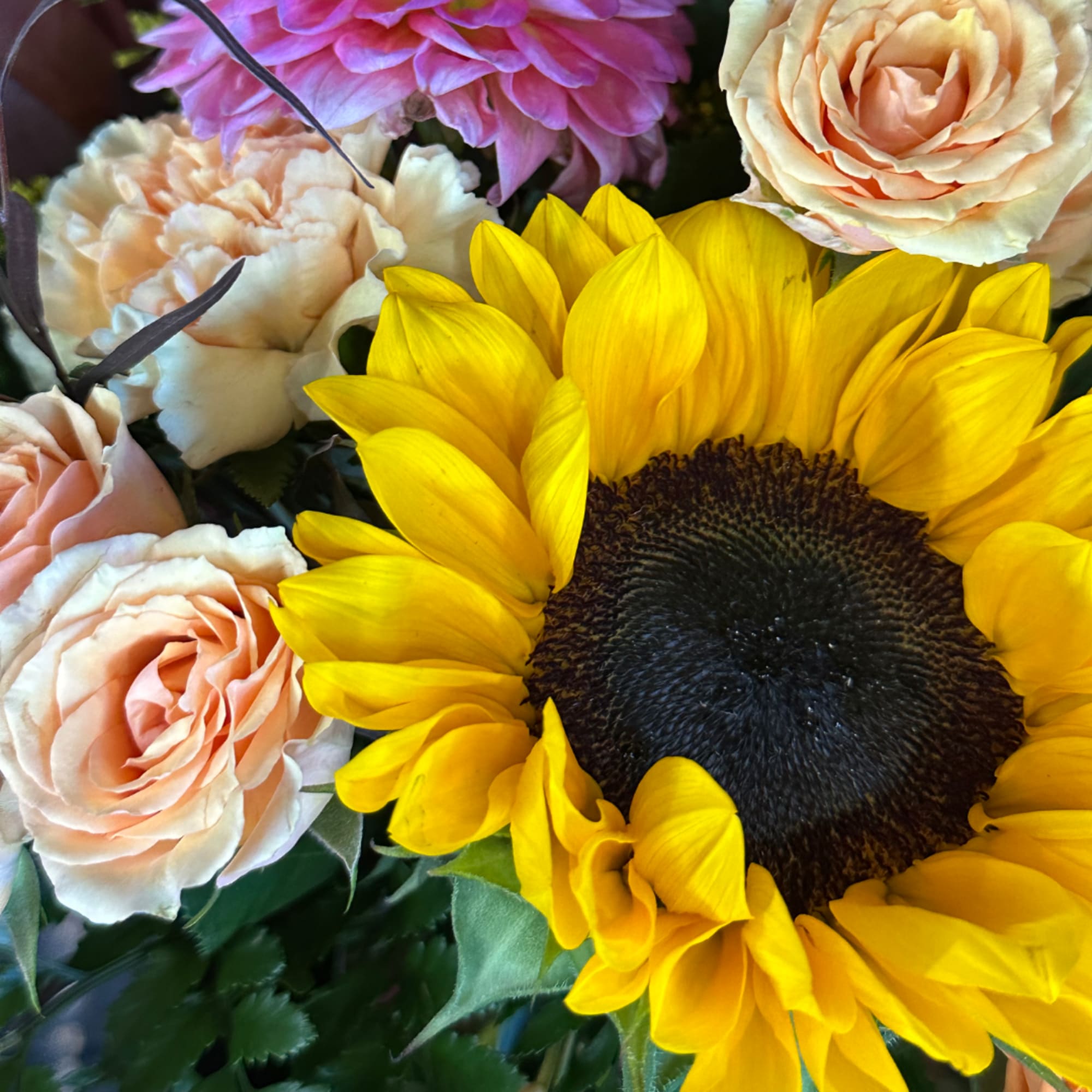 Bouquet with a large yellow sunflower and peach roses