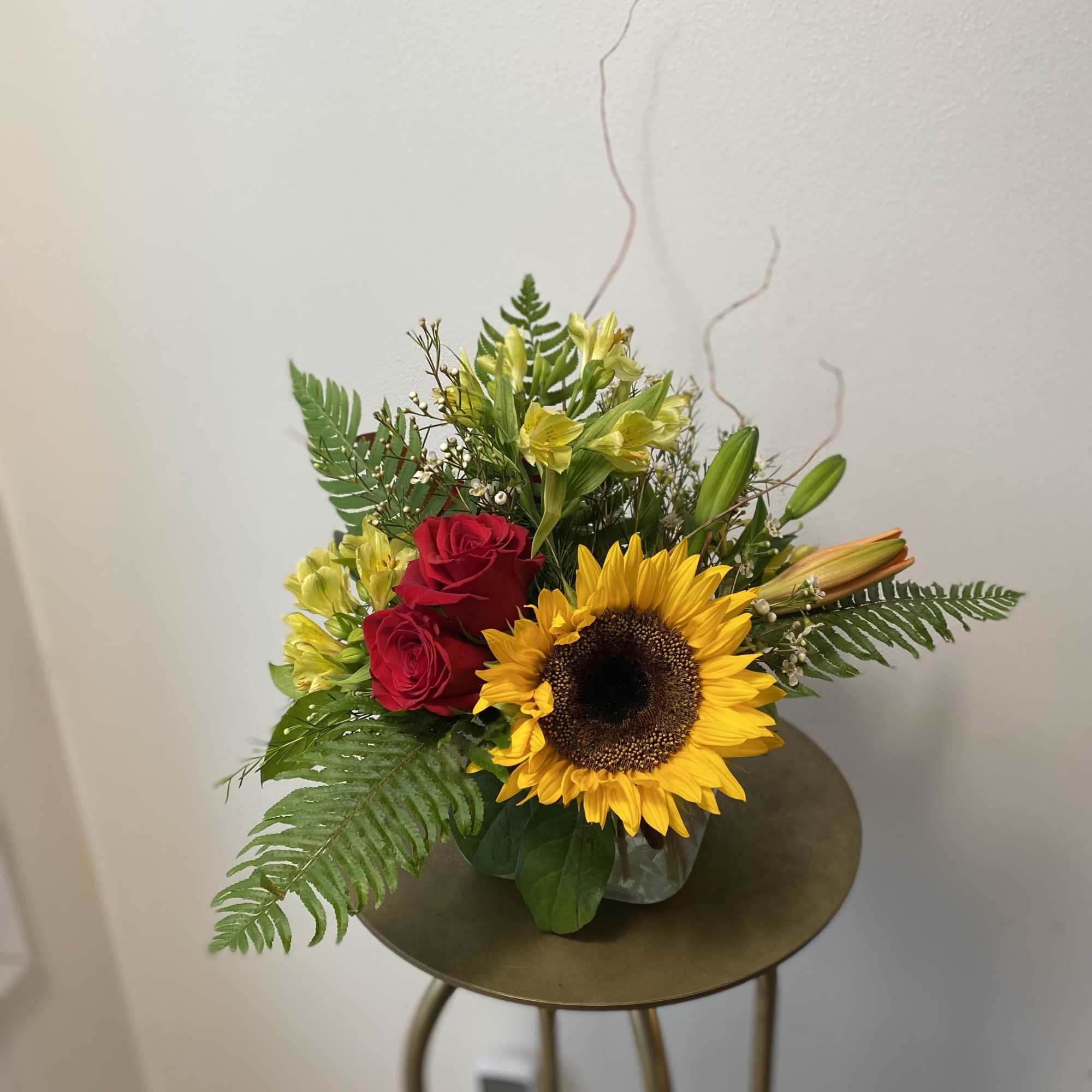 Sunflower and red rose bouquet in a clear glass vase