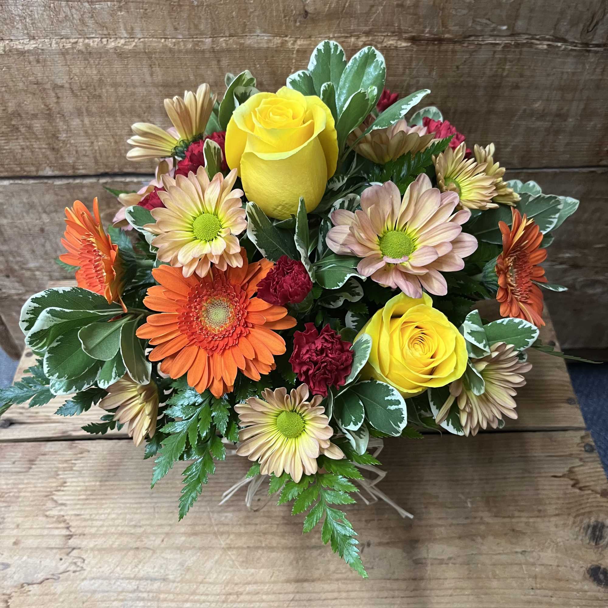 Bright, warm colors spill from a rustic terracotta pot in this cheerful, photo 2 of 2