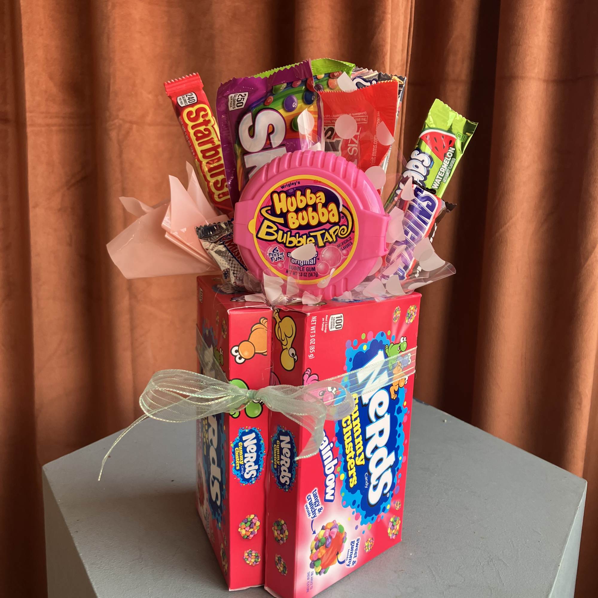 Candy gift arrangement with gum packs and a pink bubble gum container