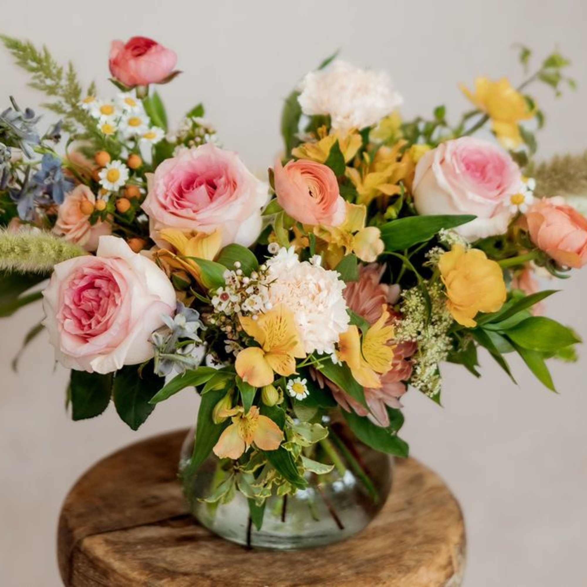 Mixed bouquet of pink and yellow flowers in a glass vase