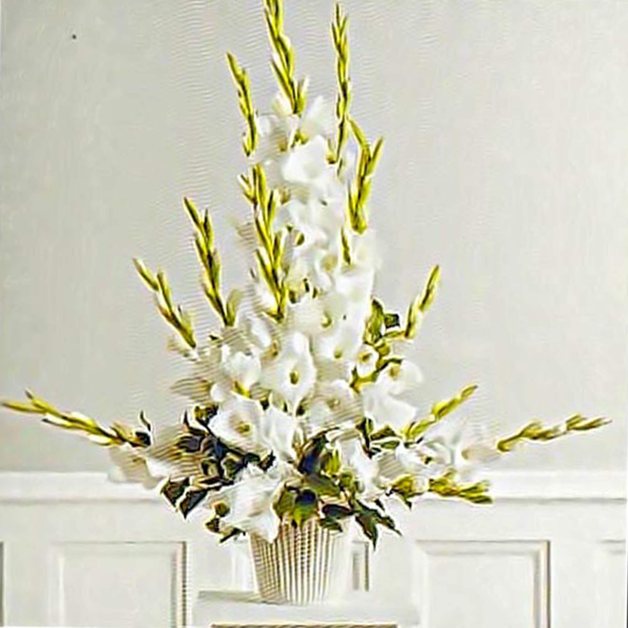 Tall white floral arrangement with vertical spikes in a white ribbed vase