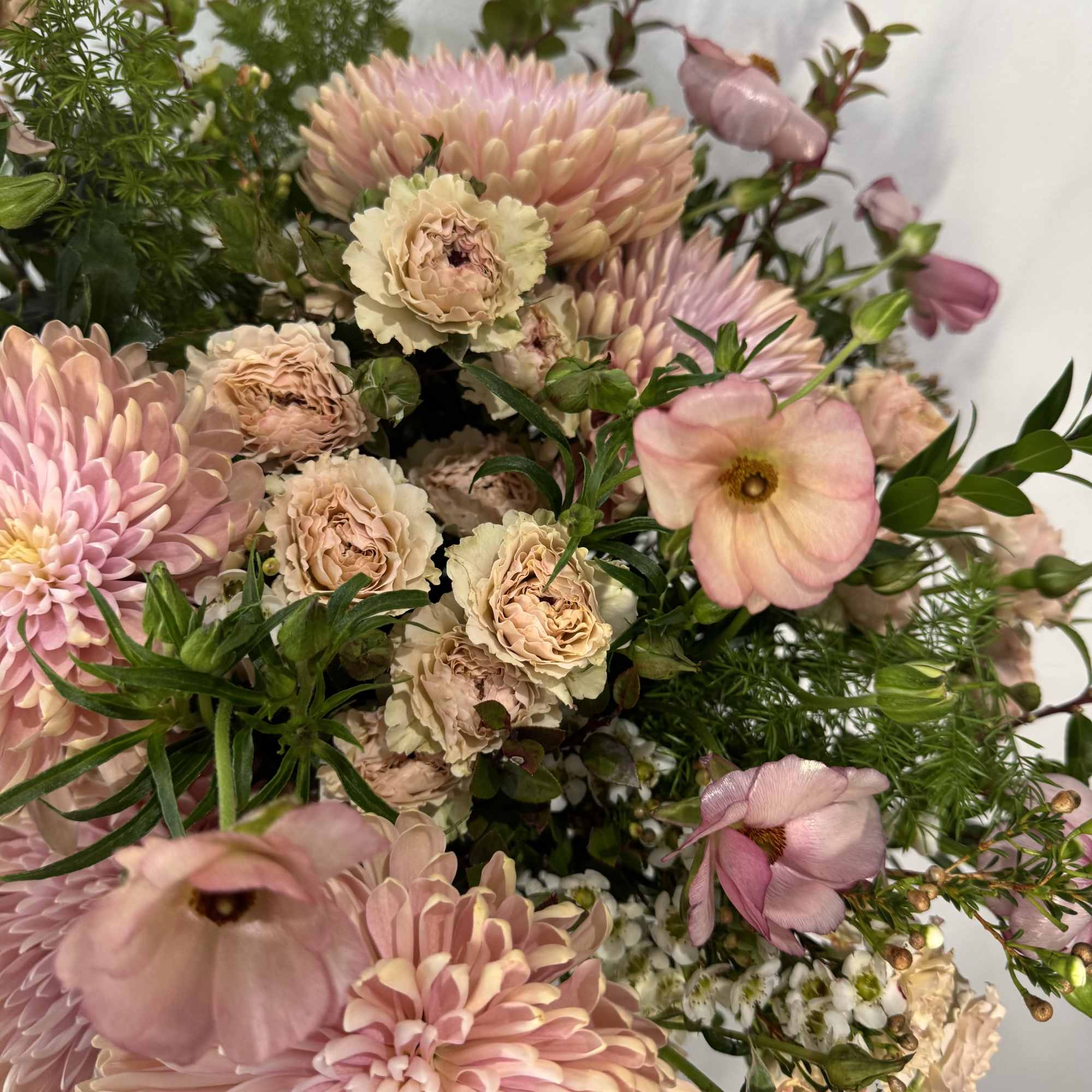 Bouquet of blush pink and cream flowers with green filler