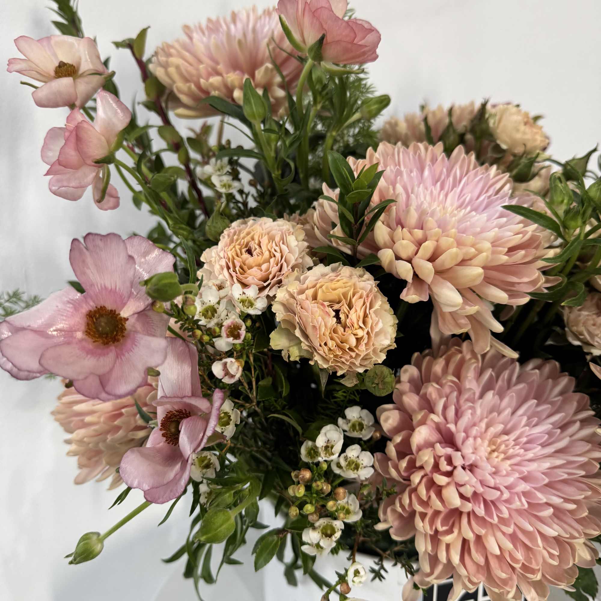 The perfect mix of peaches and pinks, spray roses, butterfly ranunculus, greens