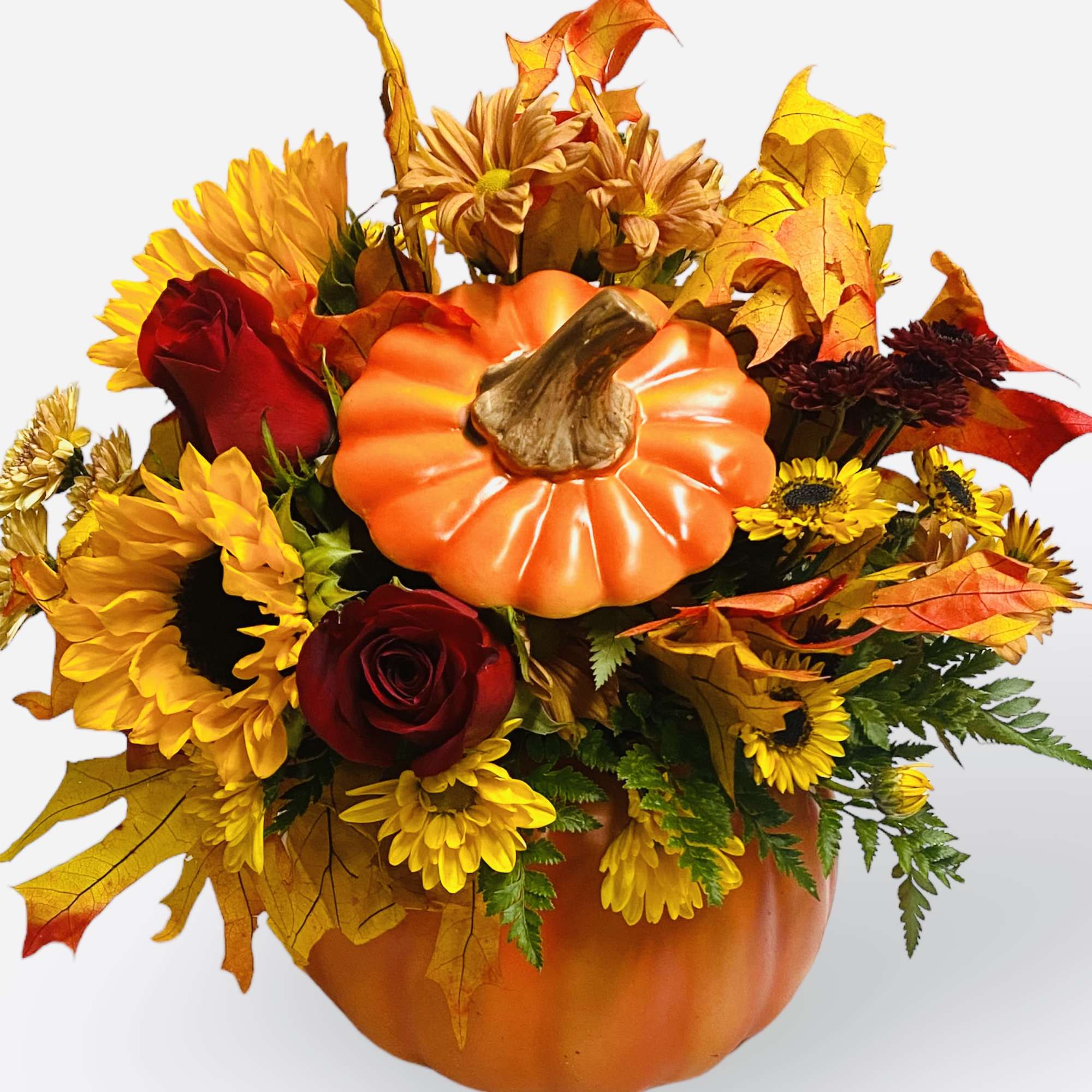Autumn floral arrangement in a pumpkin container with red roses and yellow blooms