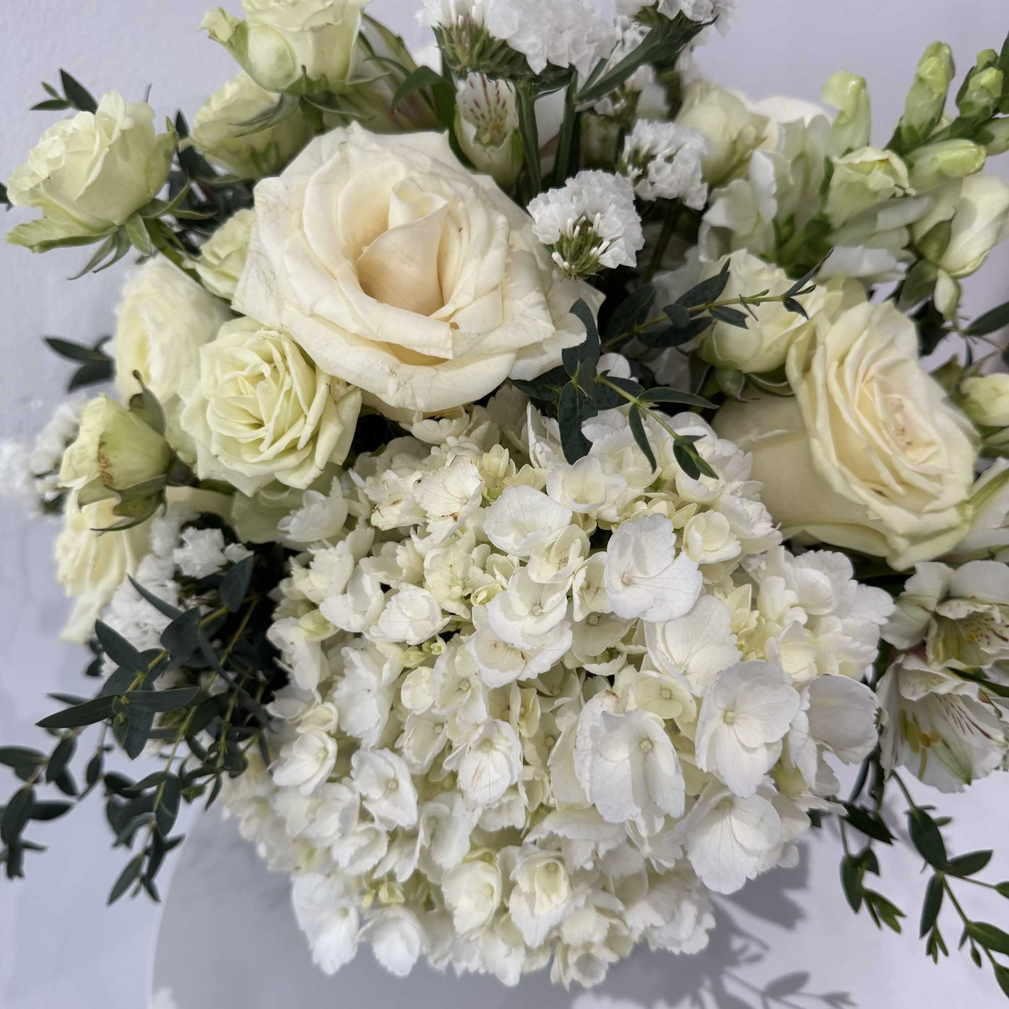 White rose and hydrangea bouquet with small white filler flowers