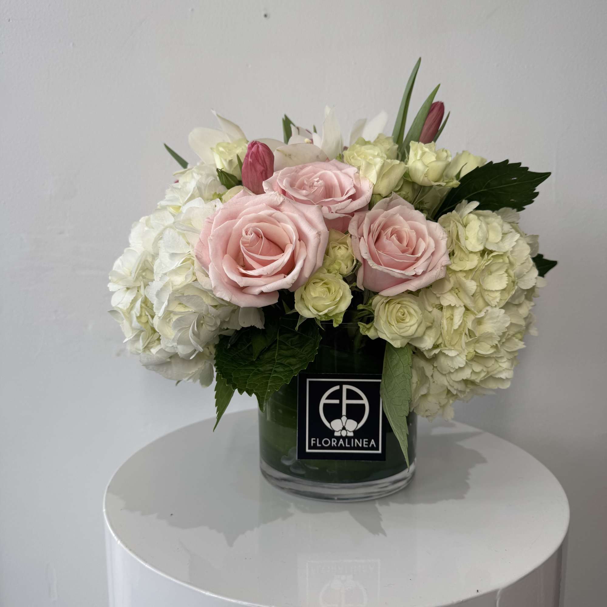 Pink roses and white hydrangeas arranged in a glass vase