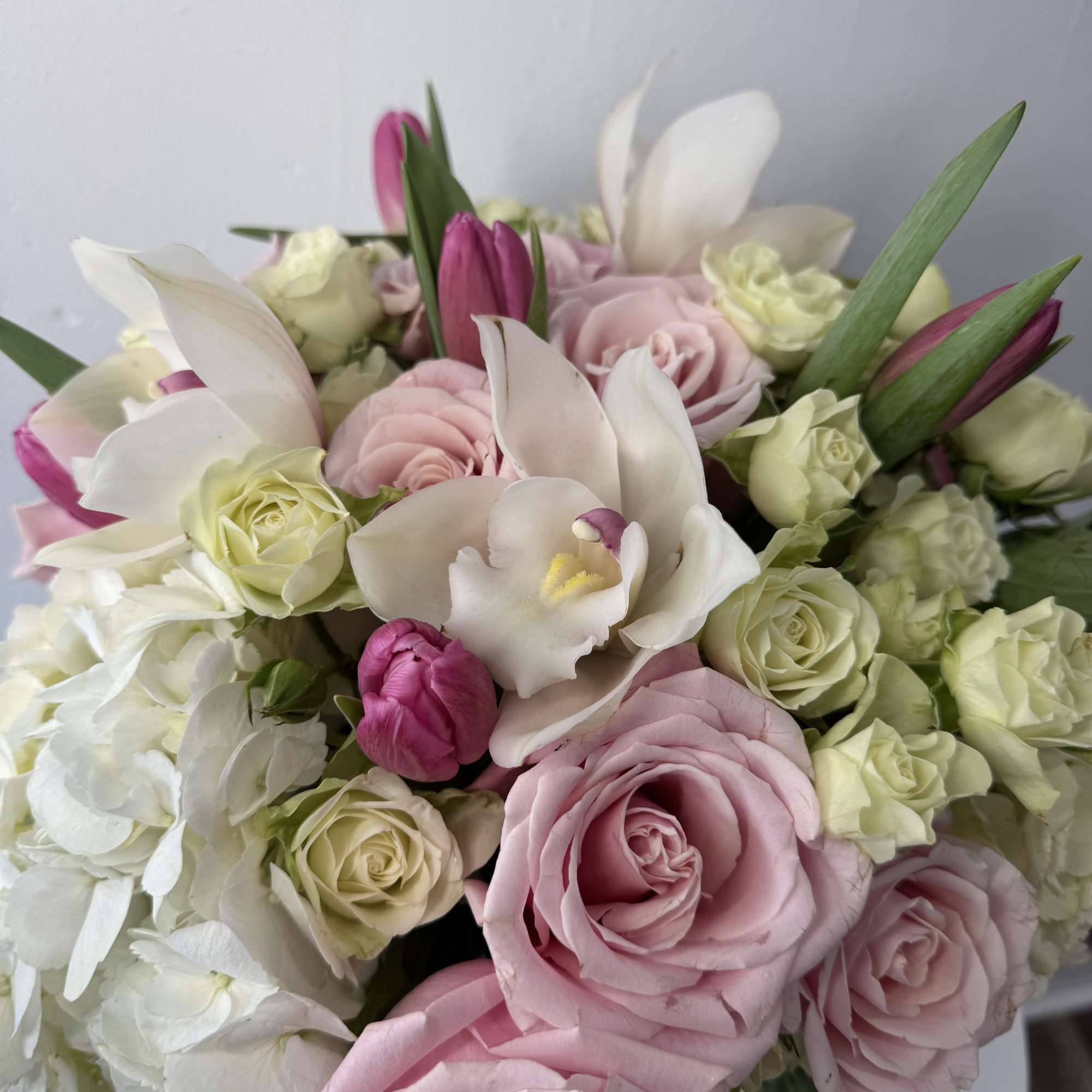 Bouquet of pink and white roses with white orchids and tulips