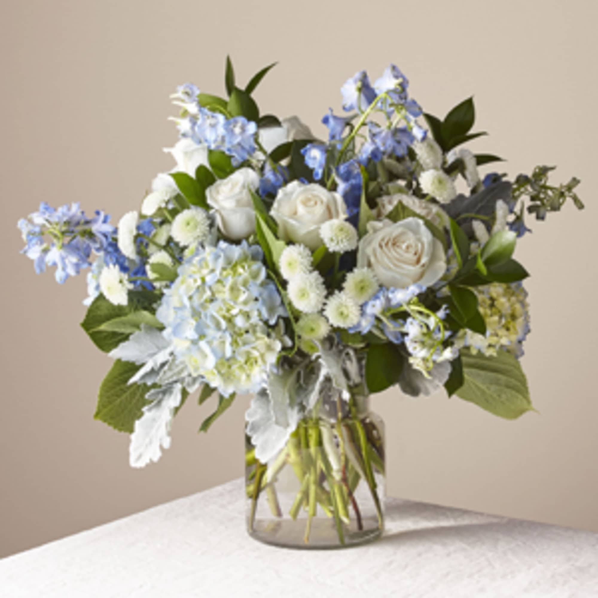 Blue and white flower arrangement in a clear glass vase