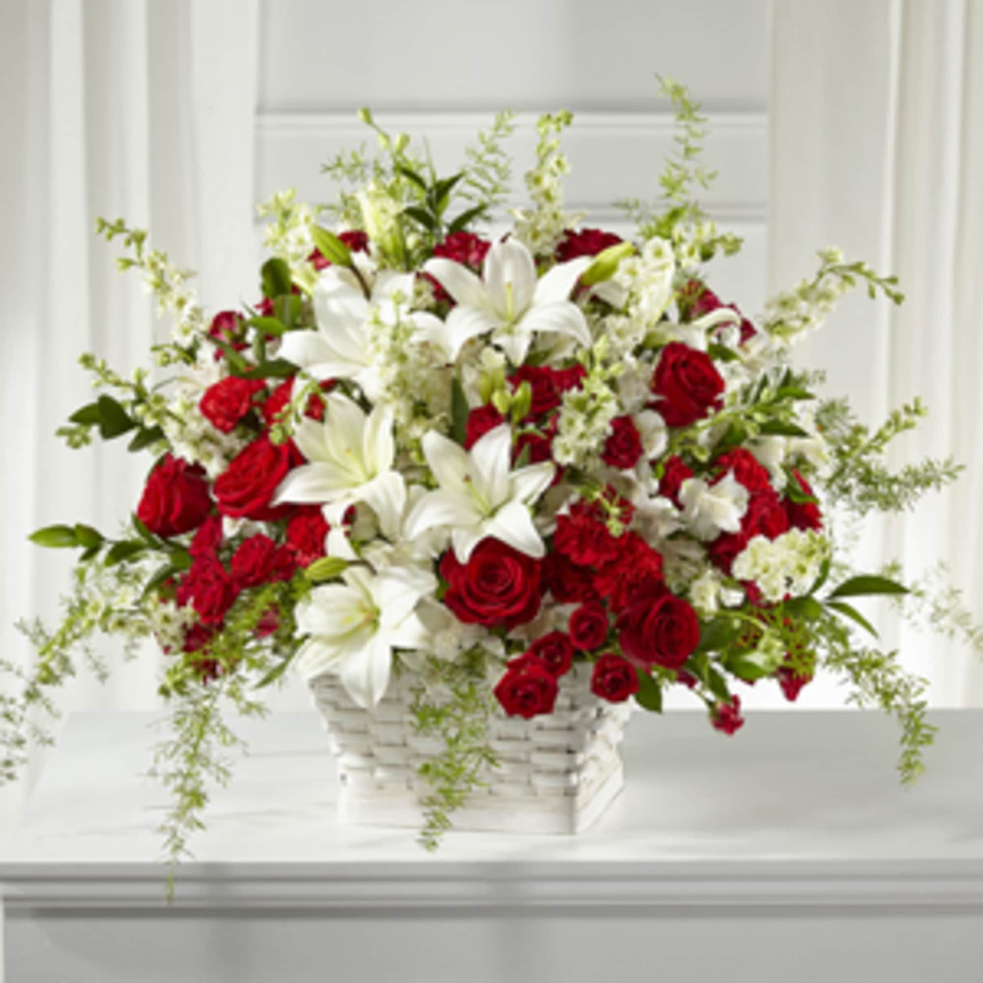Red roses and white lilies in a white basket
