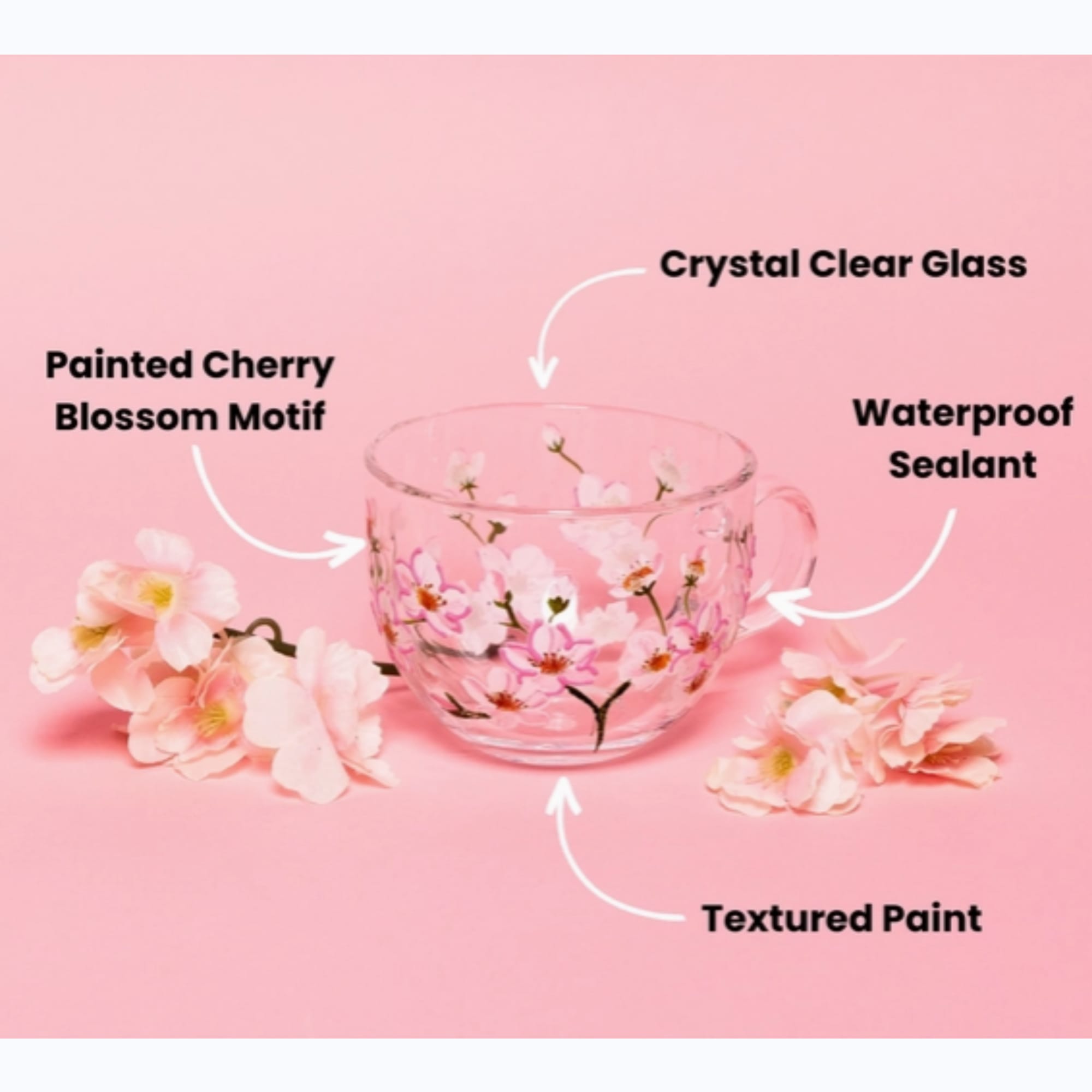 Clear glass cup with pink cherry blossom design on a pink background