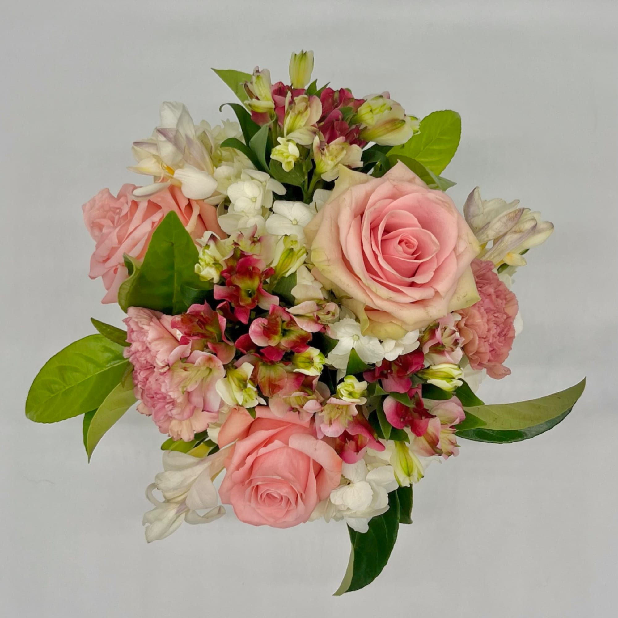 Pink roses and mixed blooms arranged in a compact bouquet