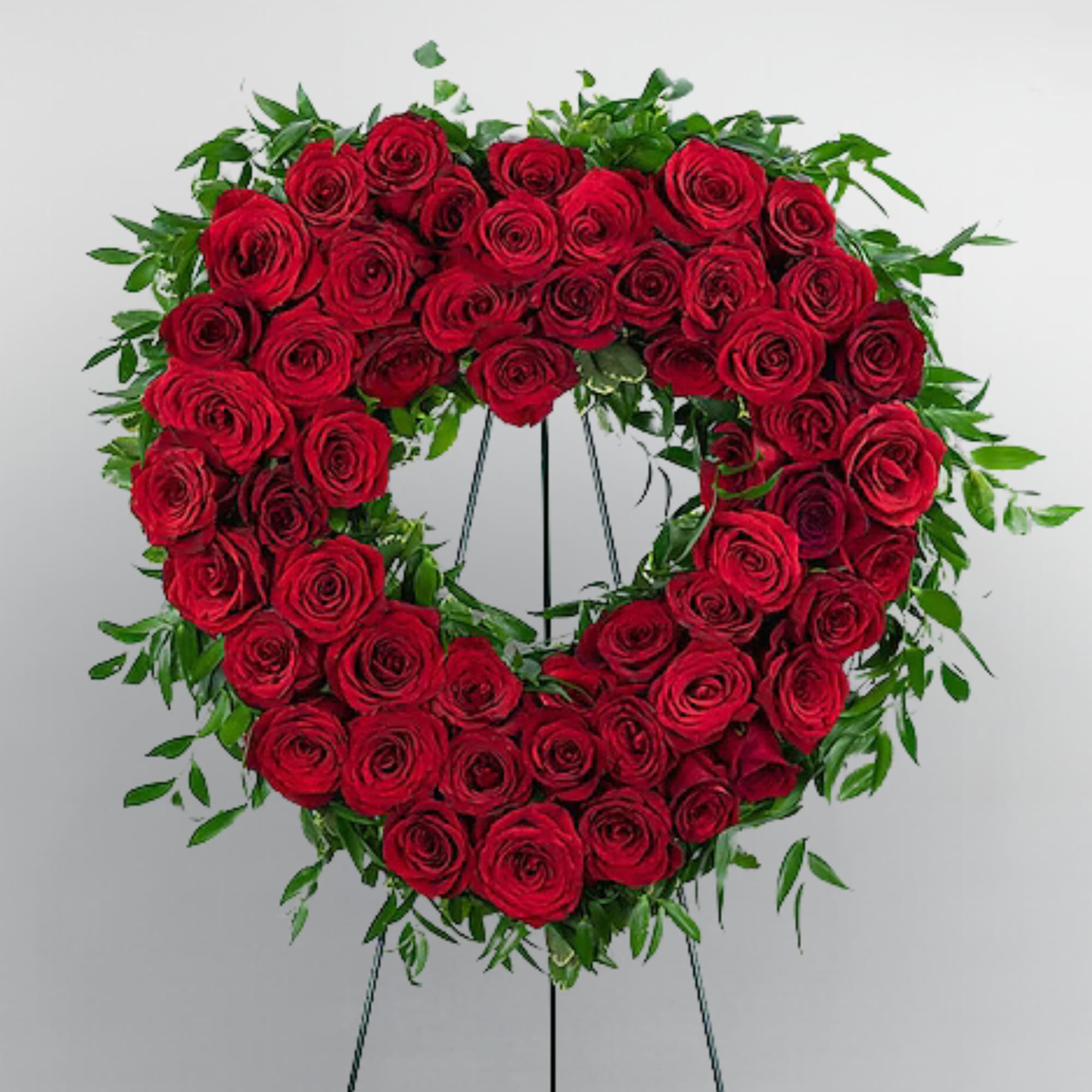 Heart-shaped wreath of red roses on a standing easel