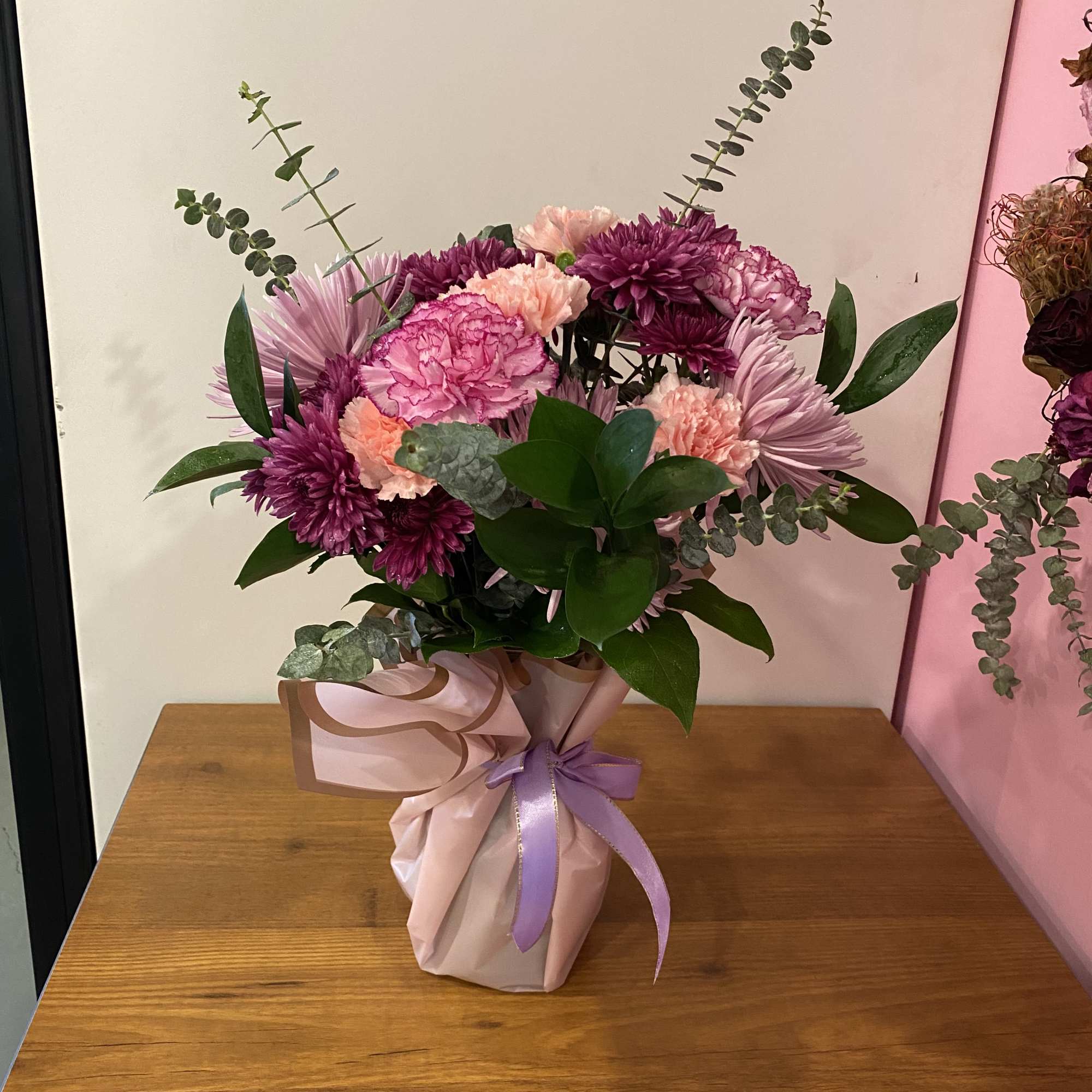 Pink and purple bouquet in wrapped paper with a ribbon