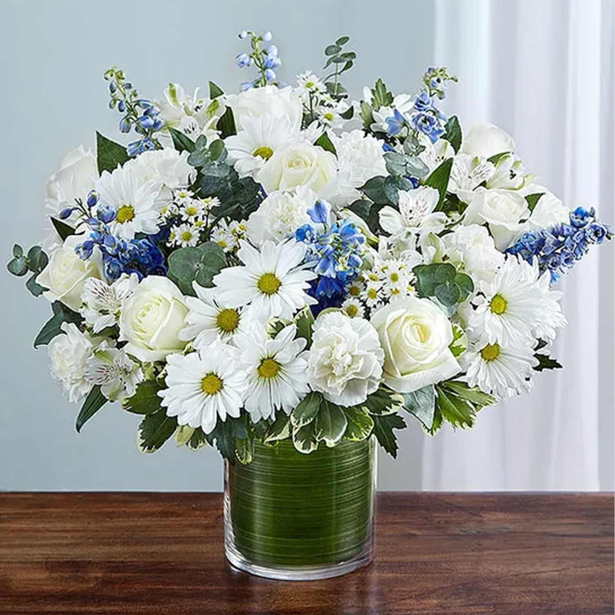 All white arrangement of white roses, alstroemeria, carnations, daisy poms and monte