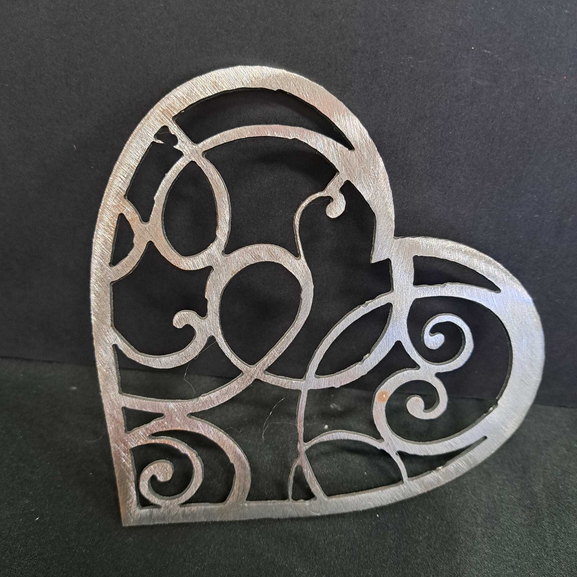 Crafted as a rigid, heart-shaped metal cutout with intricate scrollwork, the piece, photo 2 of 2