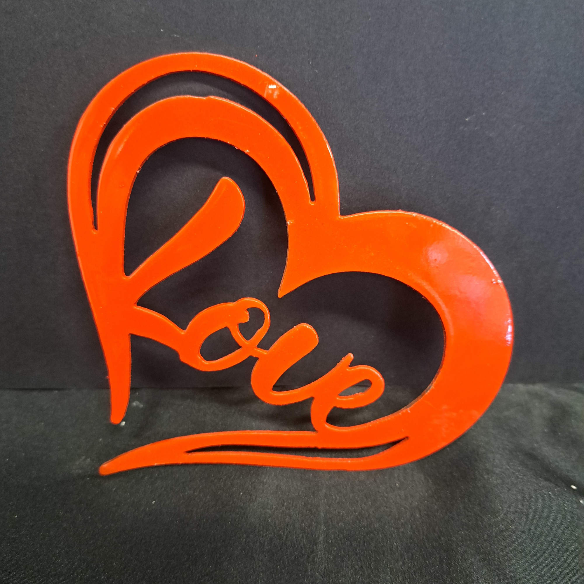 A brushed metal heart-shaped wall hanger that spells out "love" brings a, photo 2 of 2