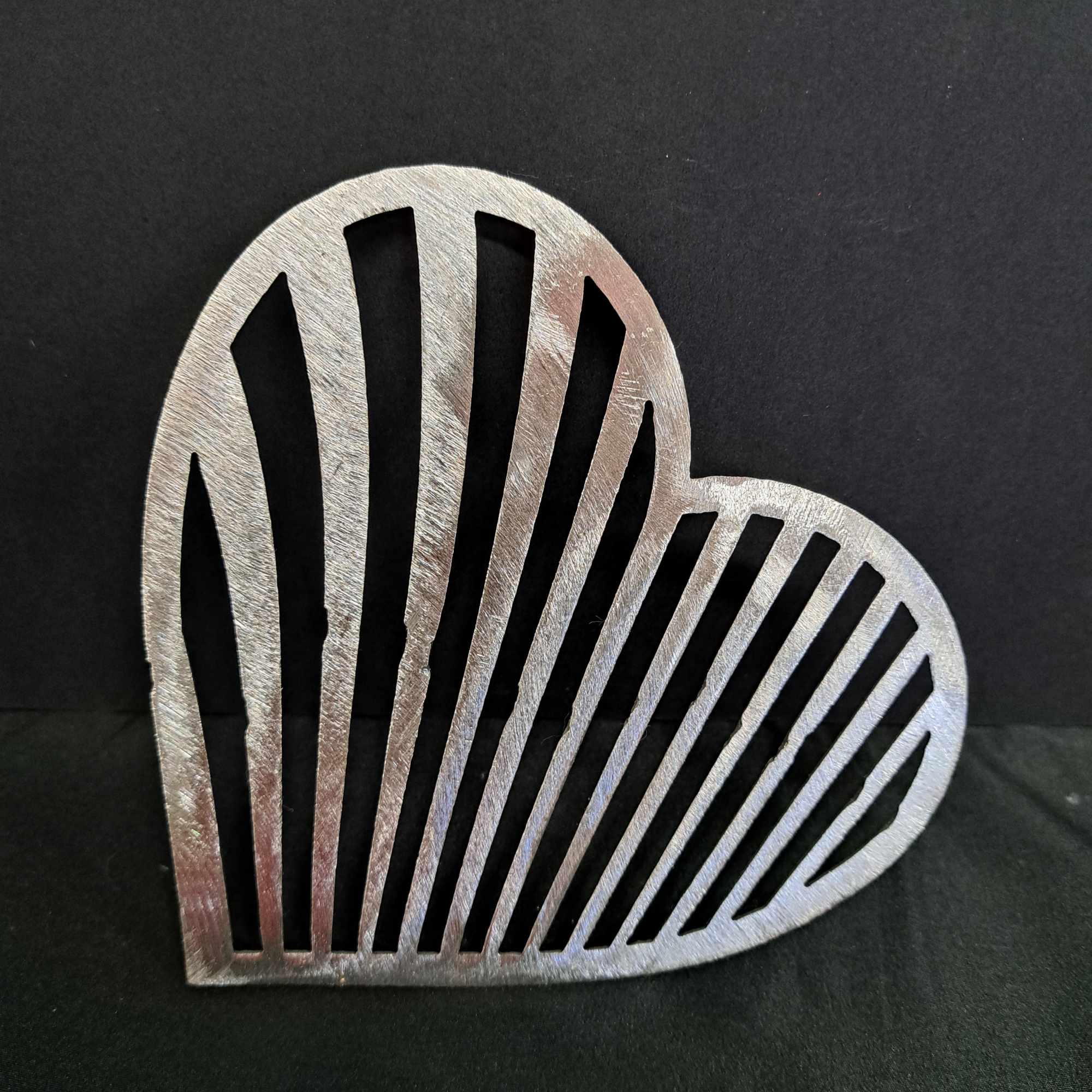 A hand-crafted metal heart wall hanger brings a graphic, romantic touch to
