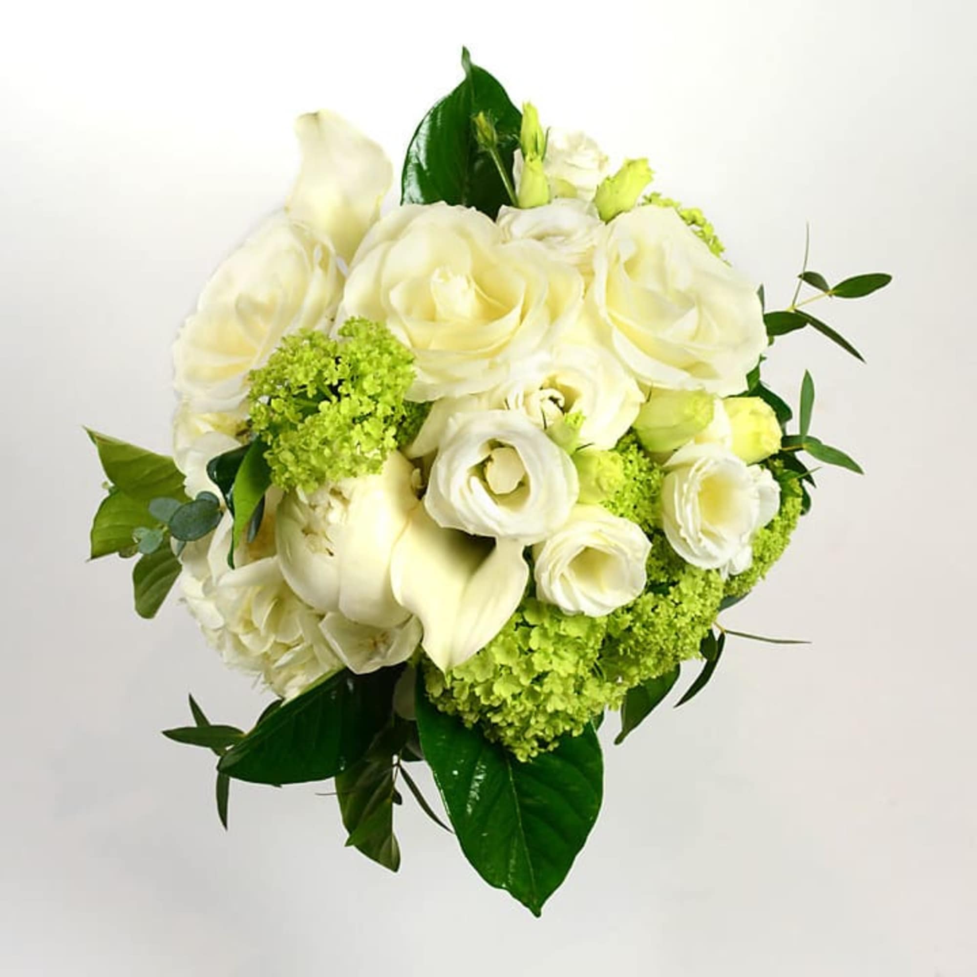 White roses and calla lilies with green accents in a bouquet