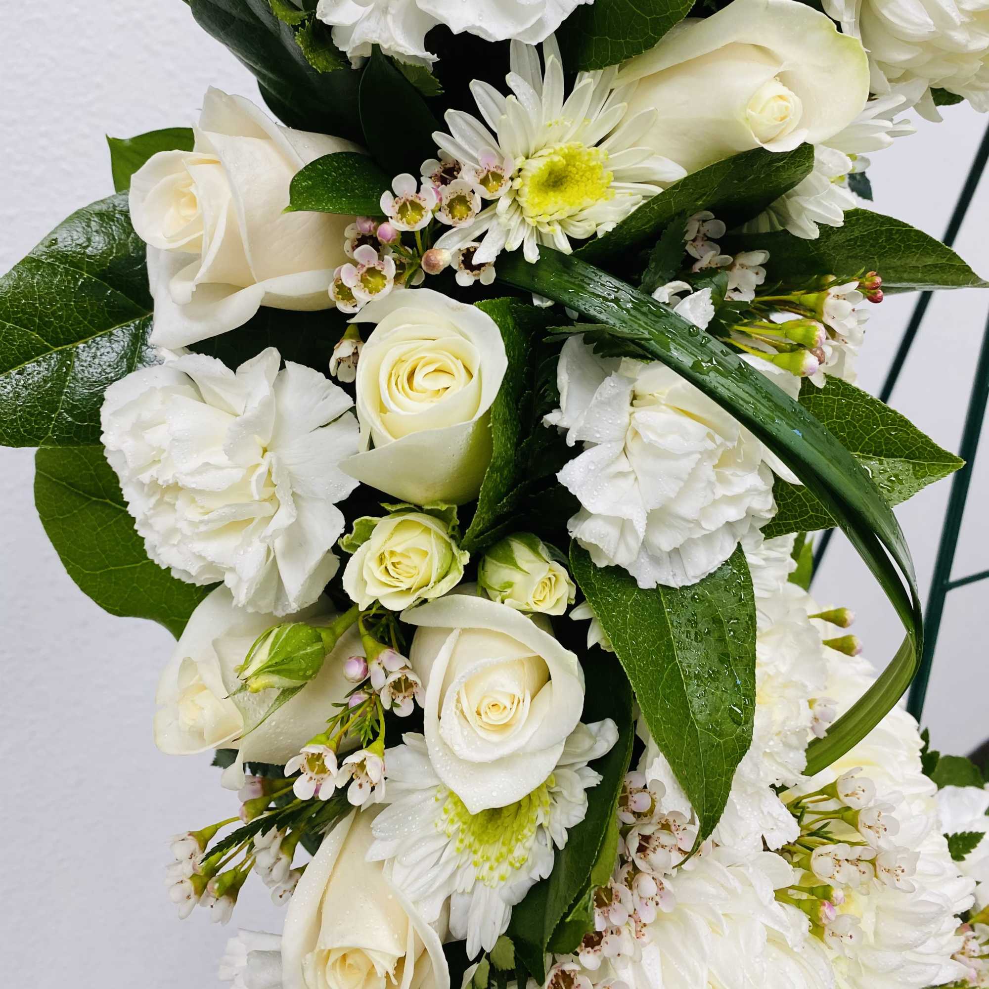 White roses and daisies arranged with small pink-white filler flowers