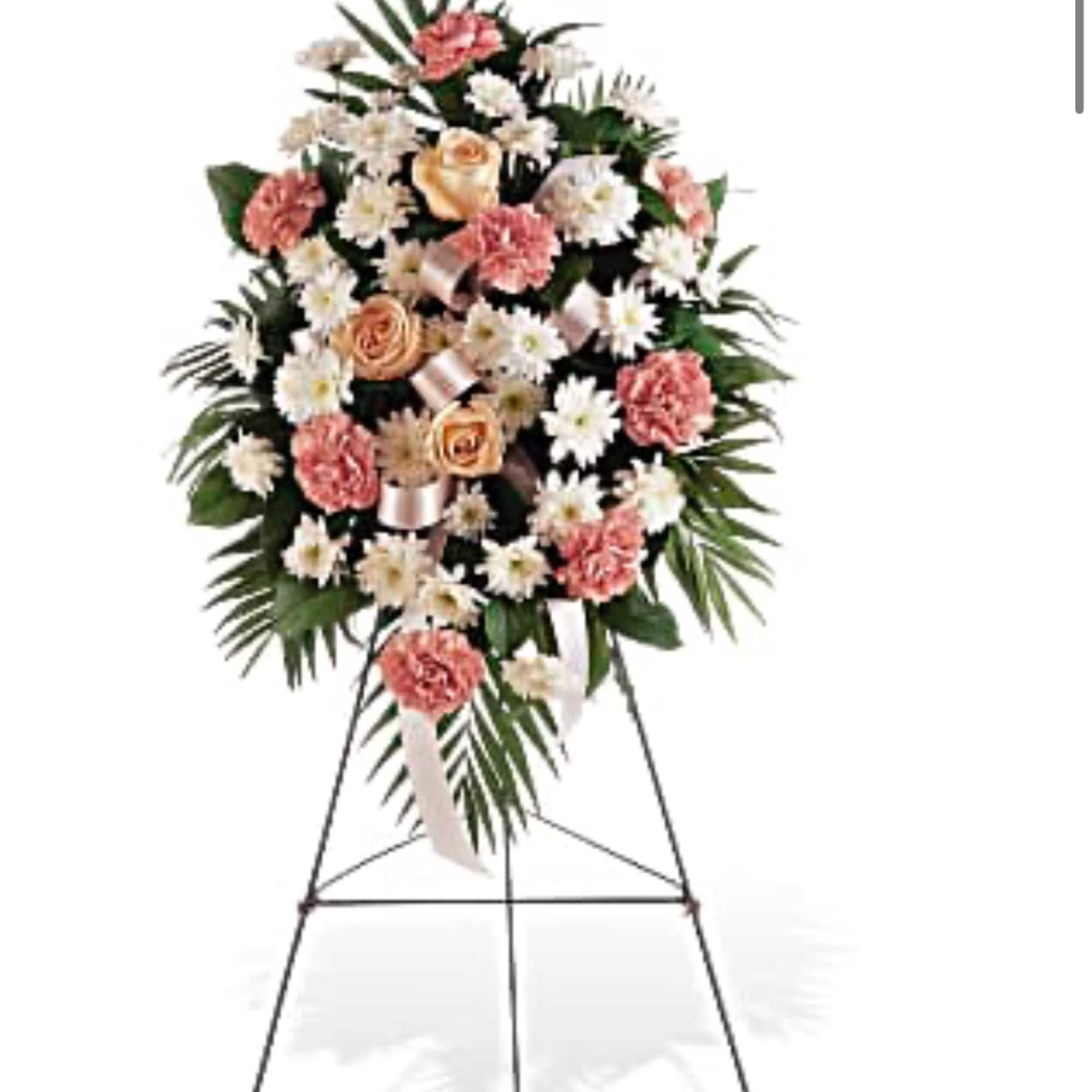 Standing floral spray with pink and white flowers on a metal easel