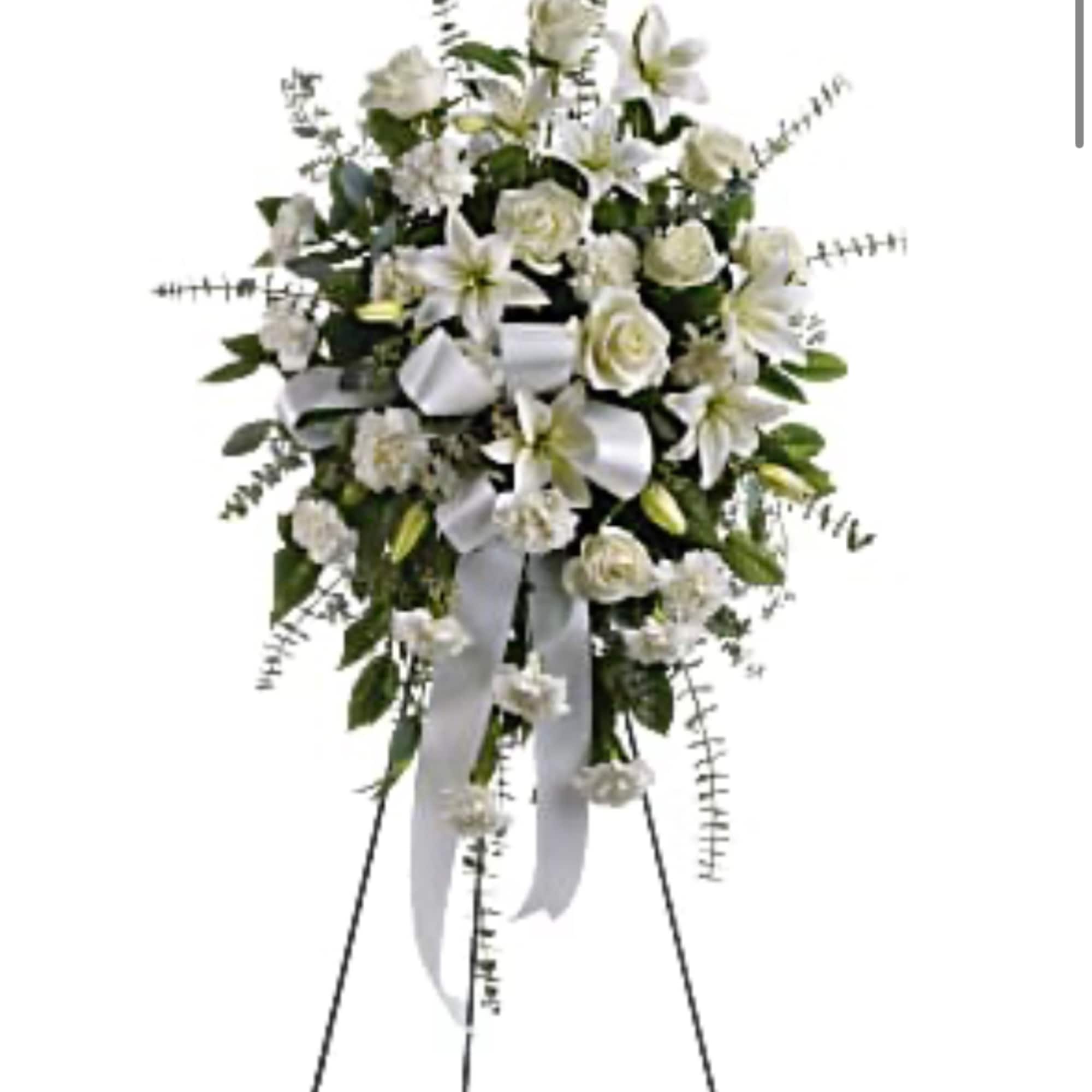 White floral standing spray with ribbon on an easel