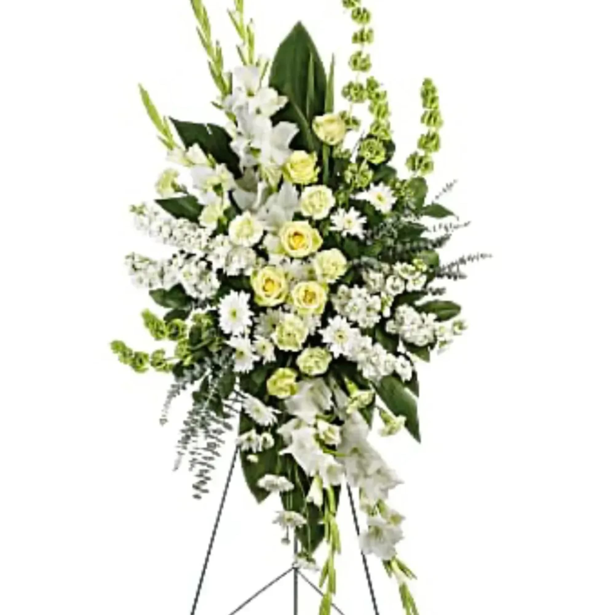 Tall white and pale yellow funeral spray on a stand