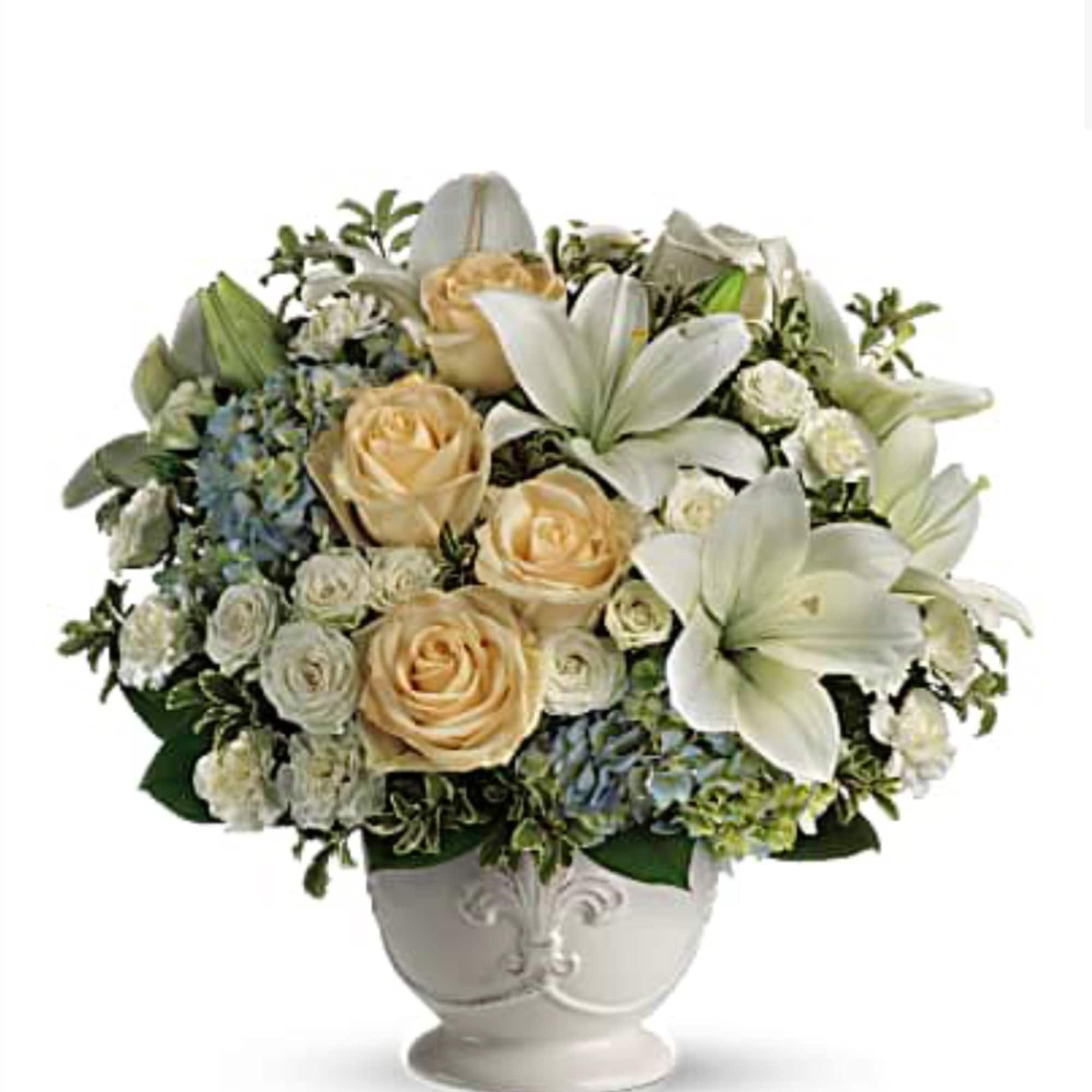 White lilies and peach roses arranged in a decorative vase