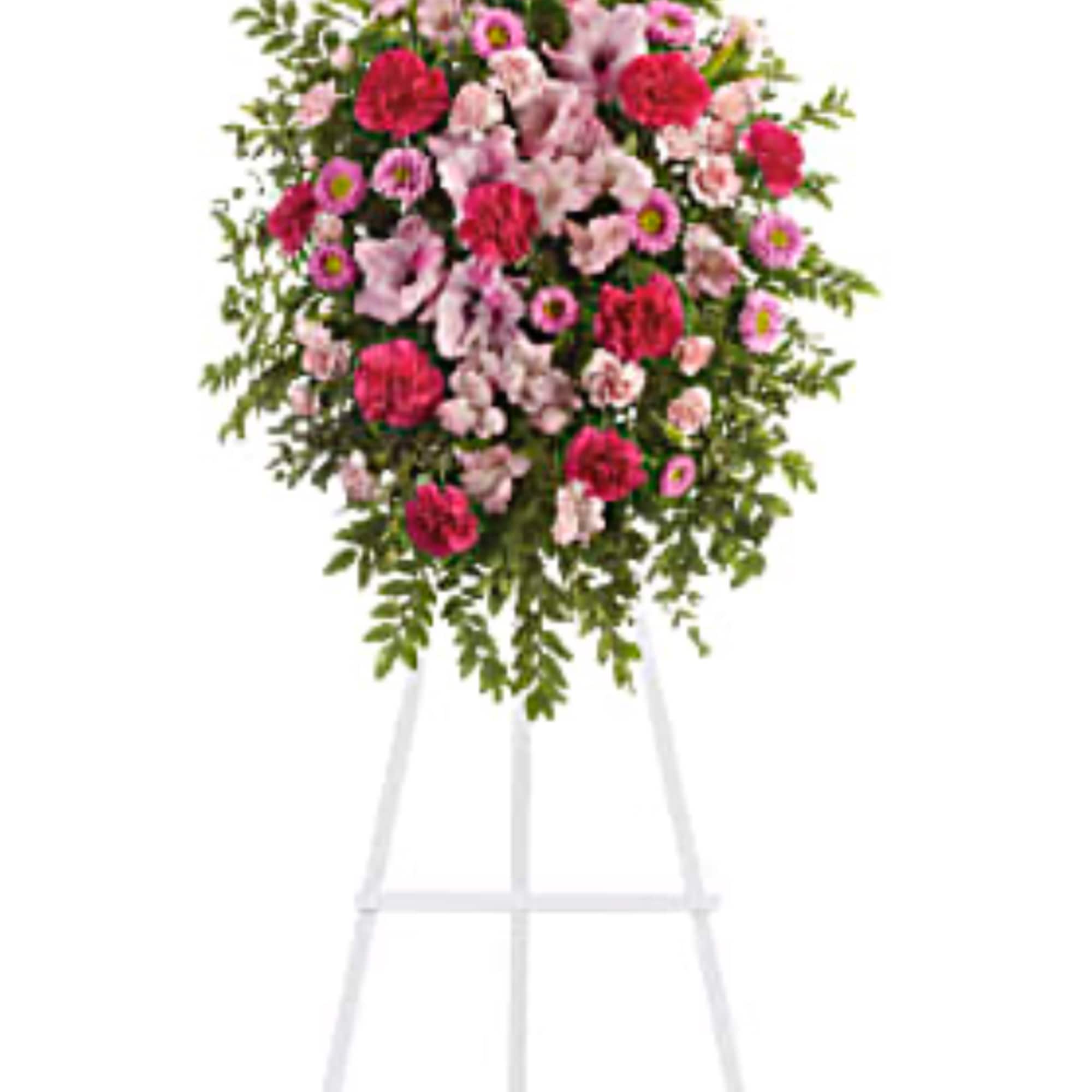 Pink and white funeral spray on a white easel