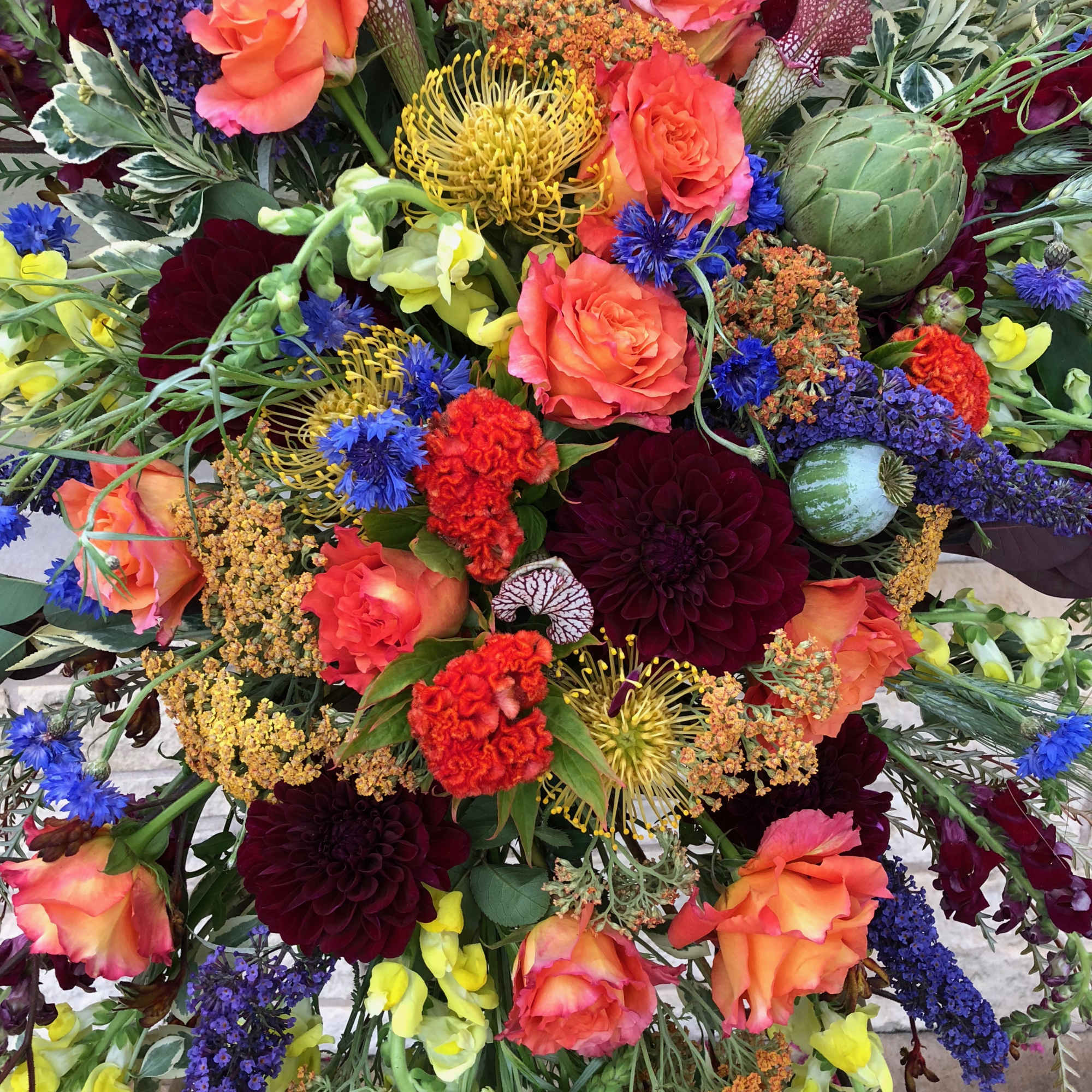 Colorful mixed bouquet with roses, dahlias, and blue accents