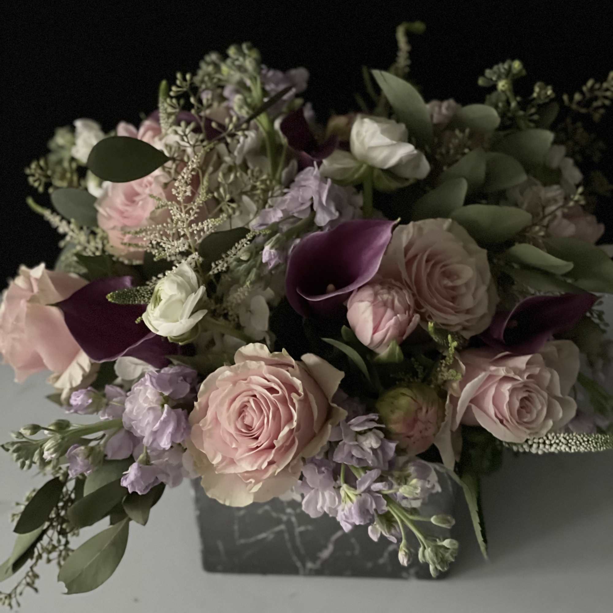 Bouquet of pale pink roses, purple calla lilies, and lavender flowers