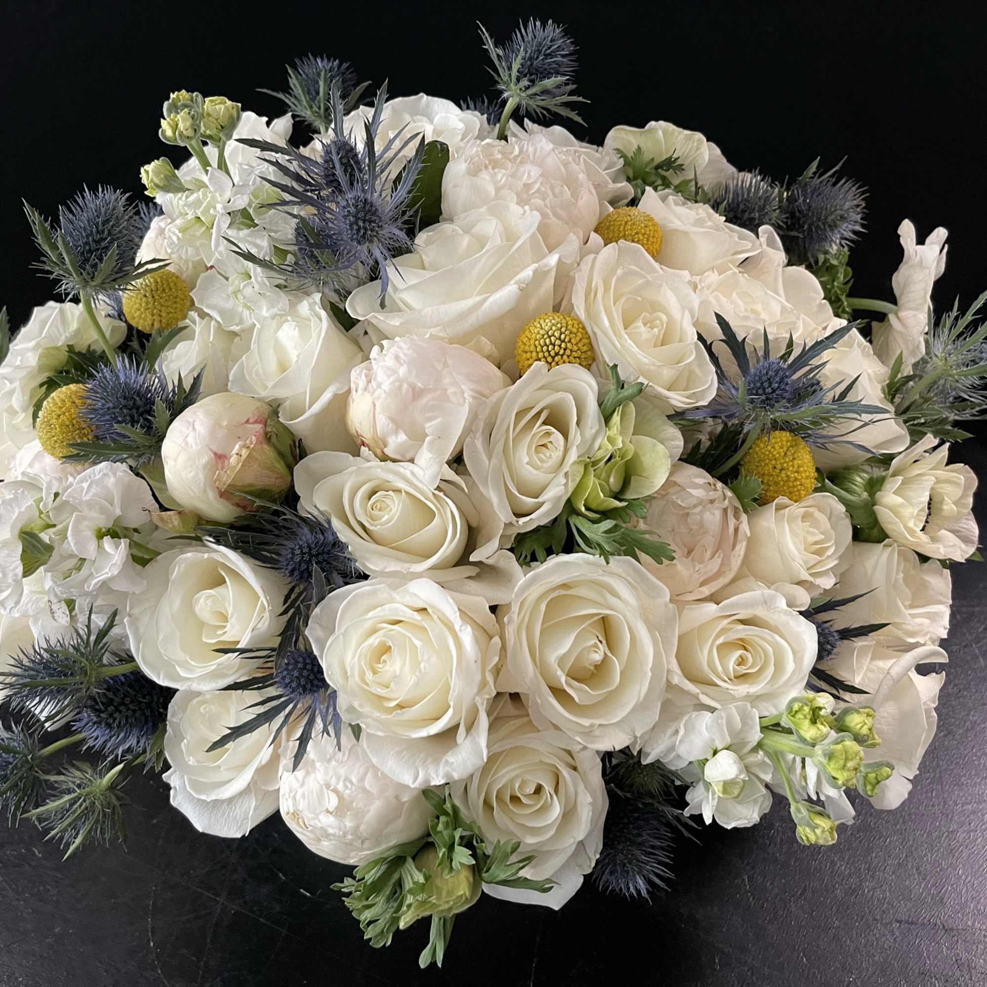 White rose bouquet with blue thistle and yellow accents, photo 7 of 9