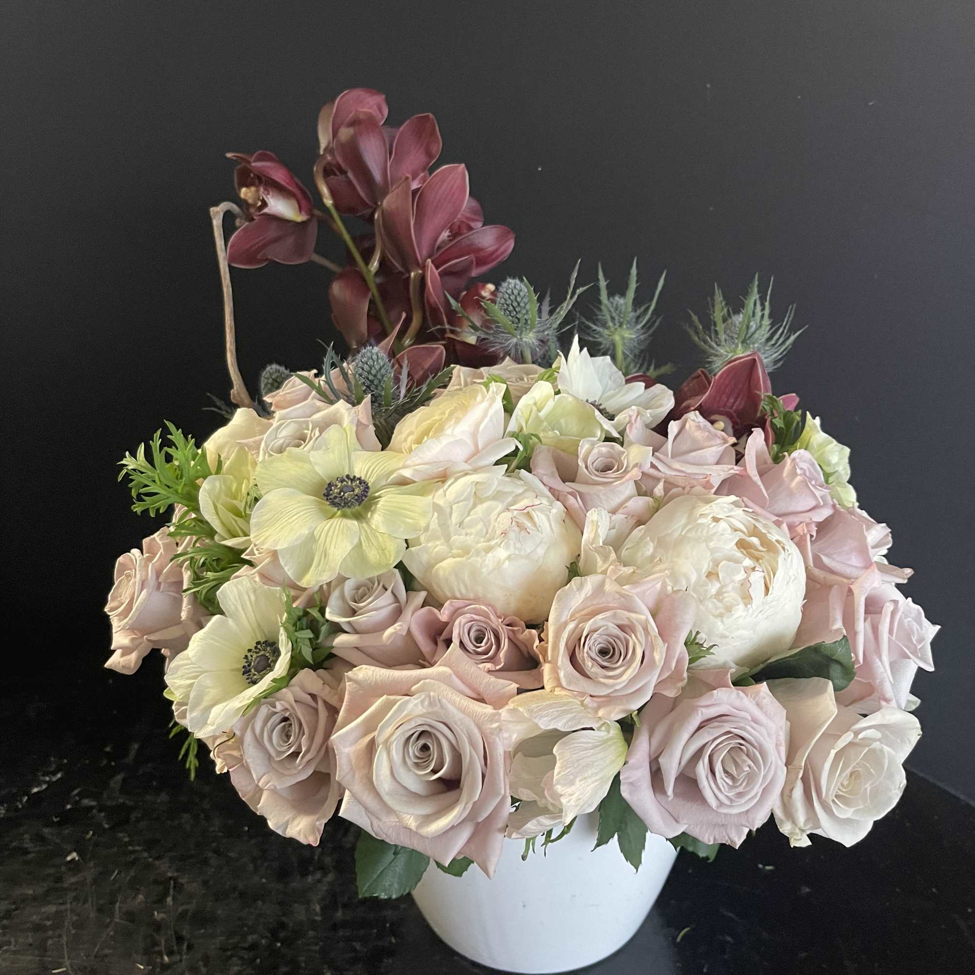 Bouquet of pale roses and cream flowers in a white vase