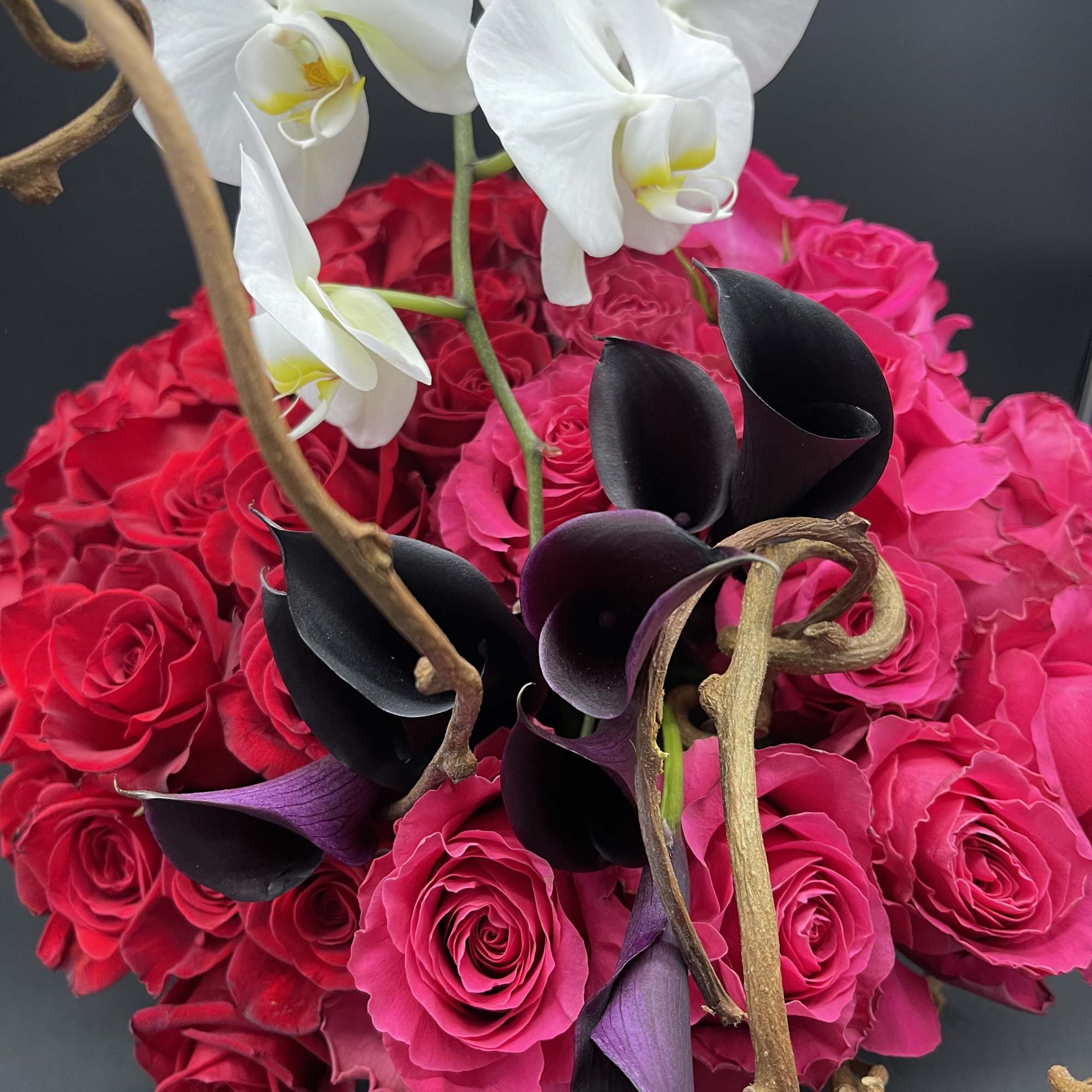 Pink rose bouquet with white orchids and dark calla lilies