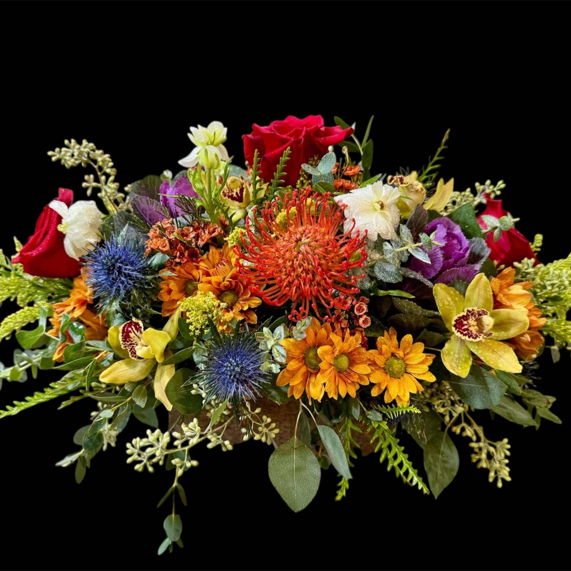Colorful mixed flower arrangement with roses and daisies on a black background