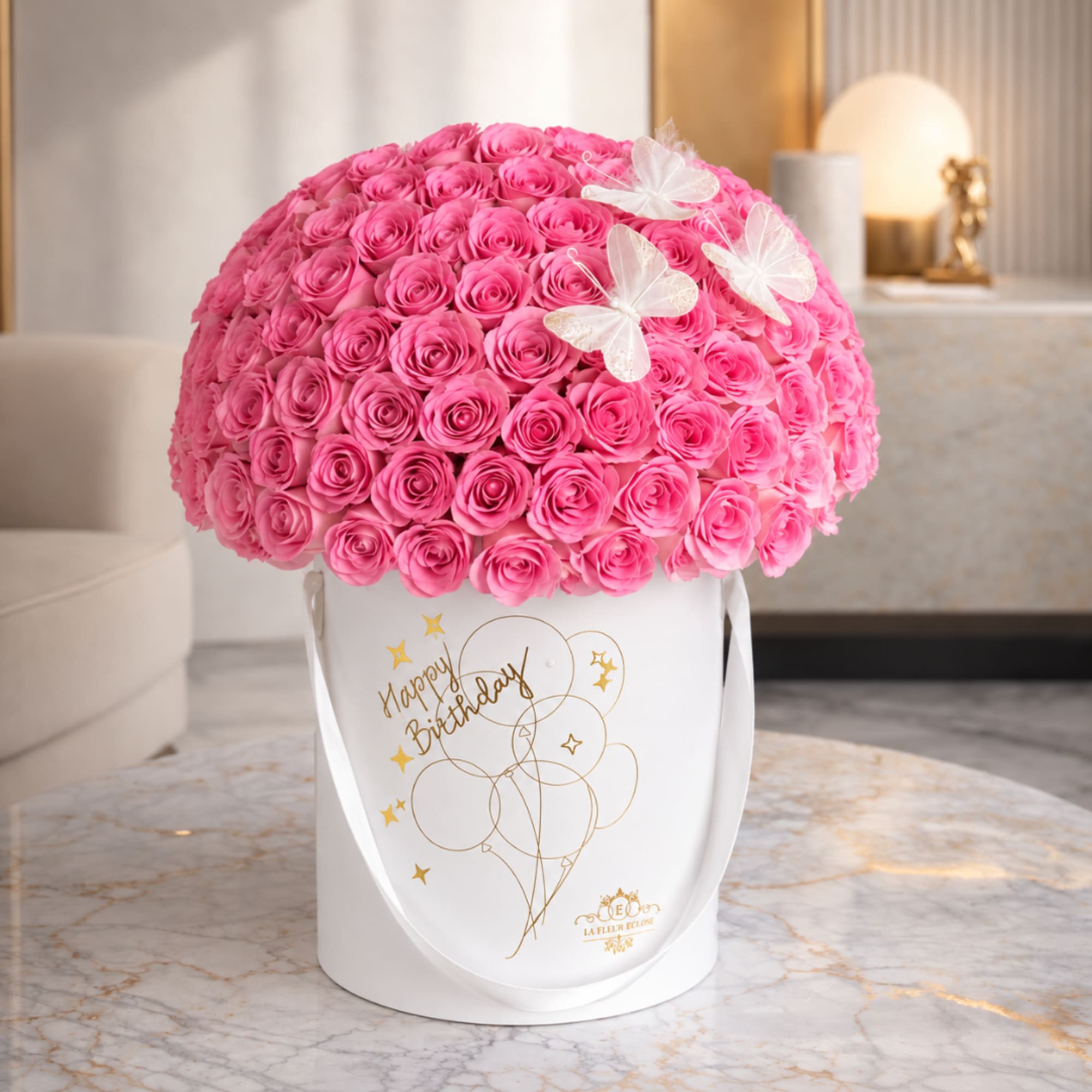 Pink rose arrangement in a white hatbox with butterfly accents