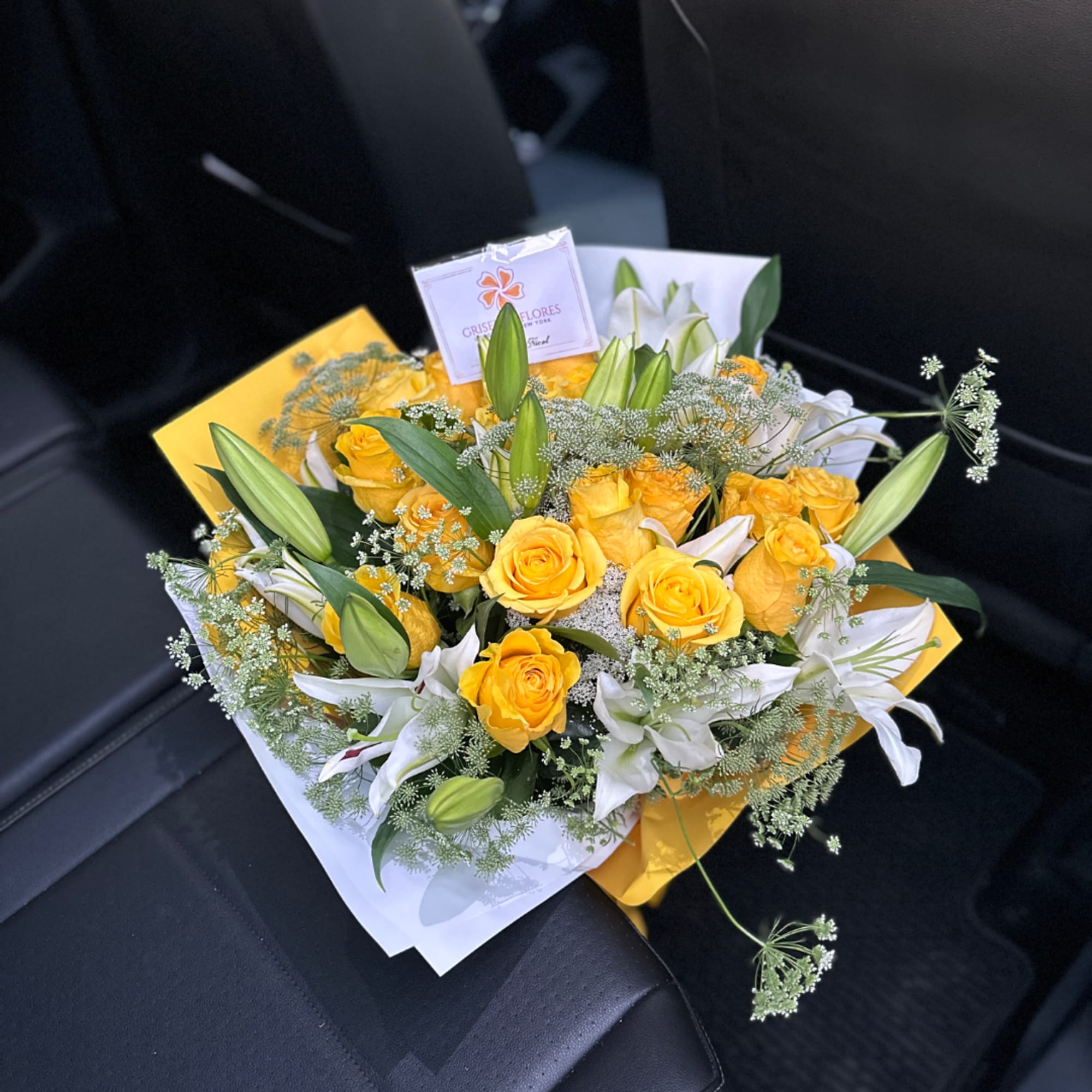 Yellow roses and white lilies in a wrapped bouquet