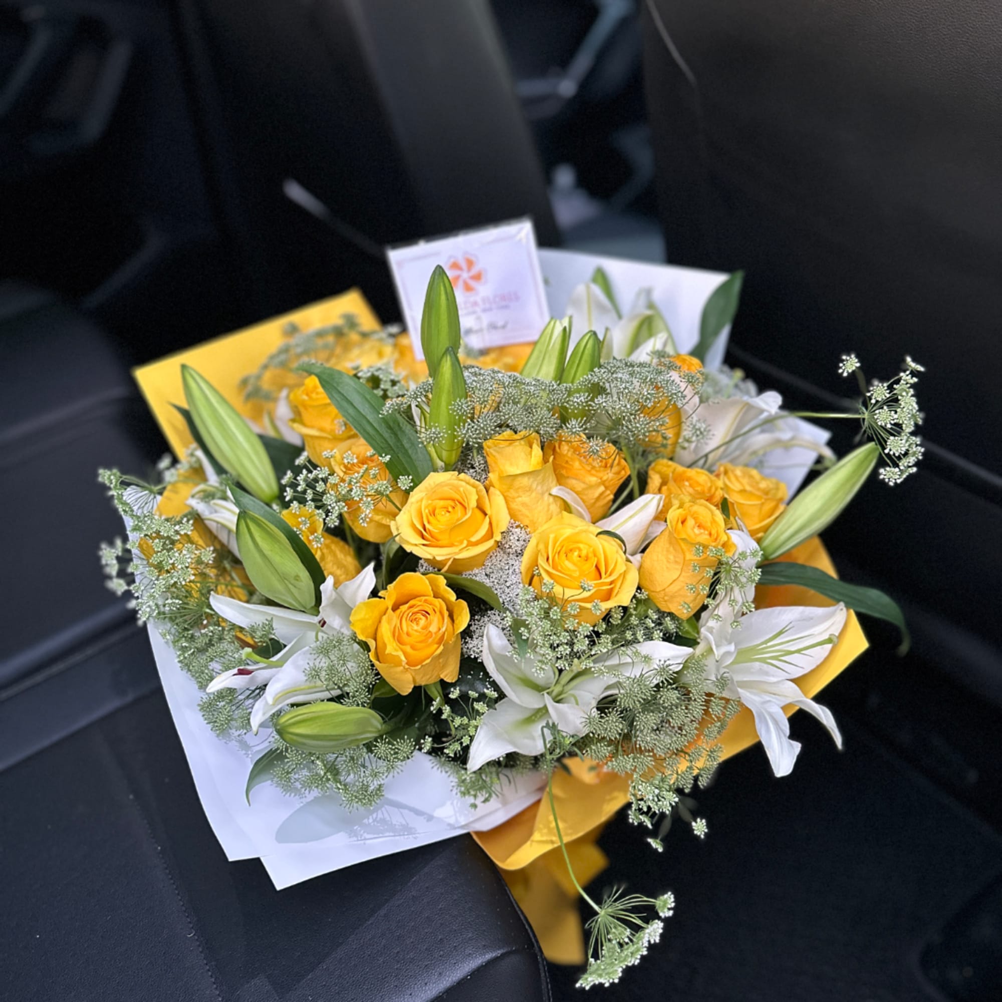 Yellow roses and white lilies in wrapped bouquet, photo 3 of 3
