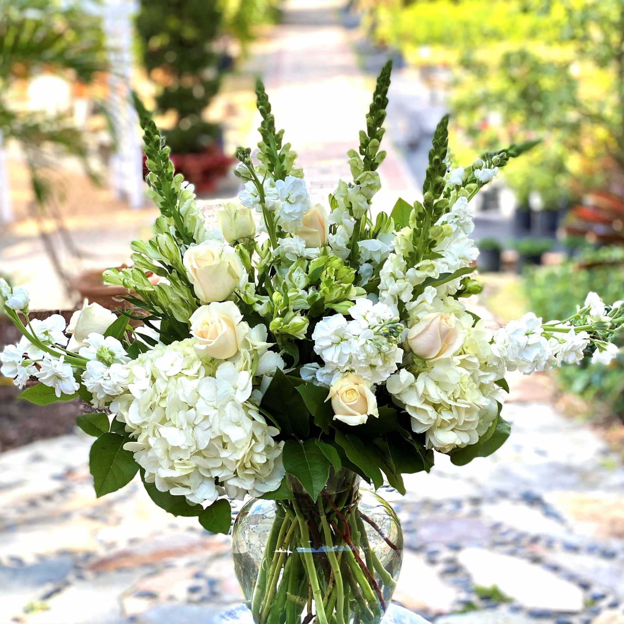 White roses and hydrangeas in a clear glass vase