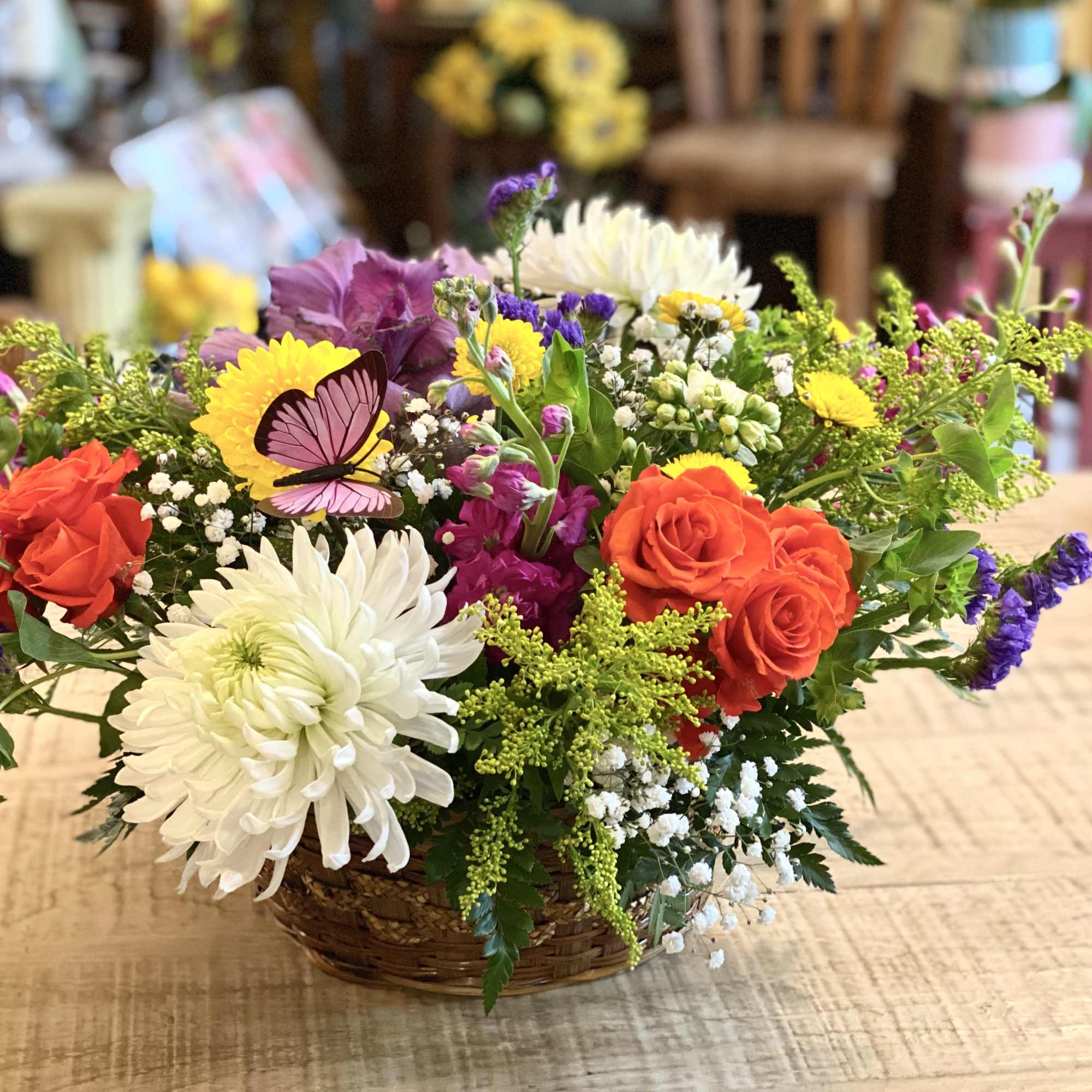 Mixed flower basket with roses, chrysanthemums, and a butterfly decoration