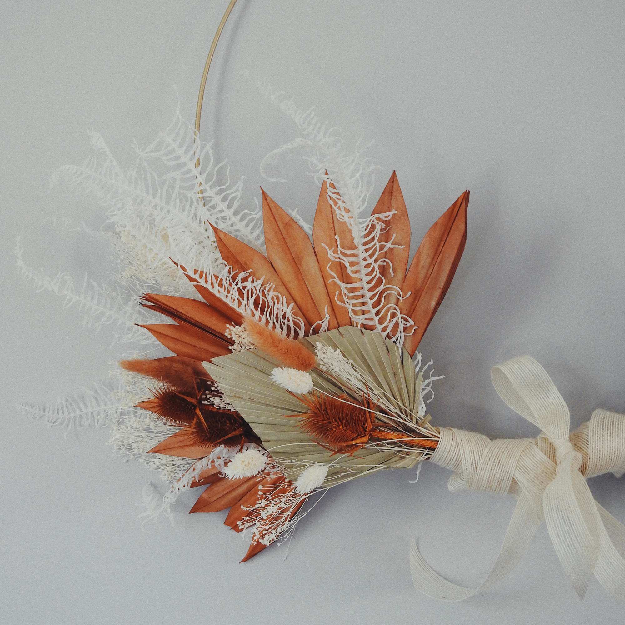 Small dried bouquet with orange and cream foliage tied with ribbon