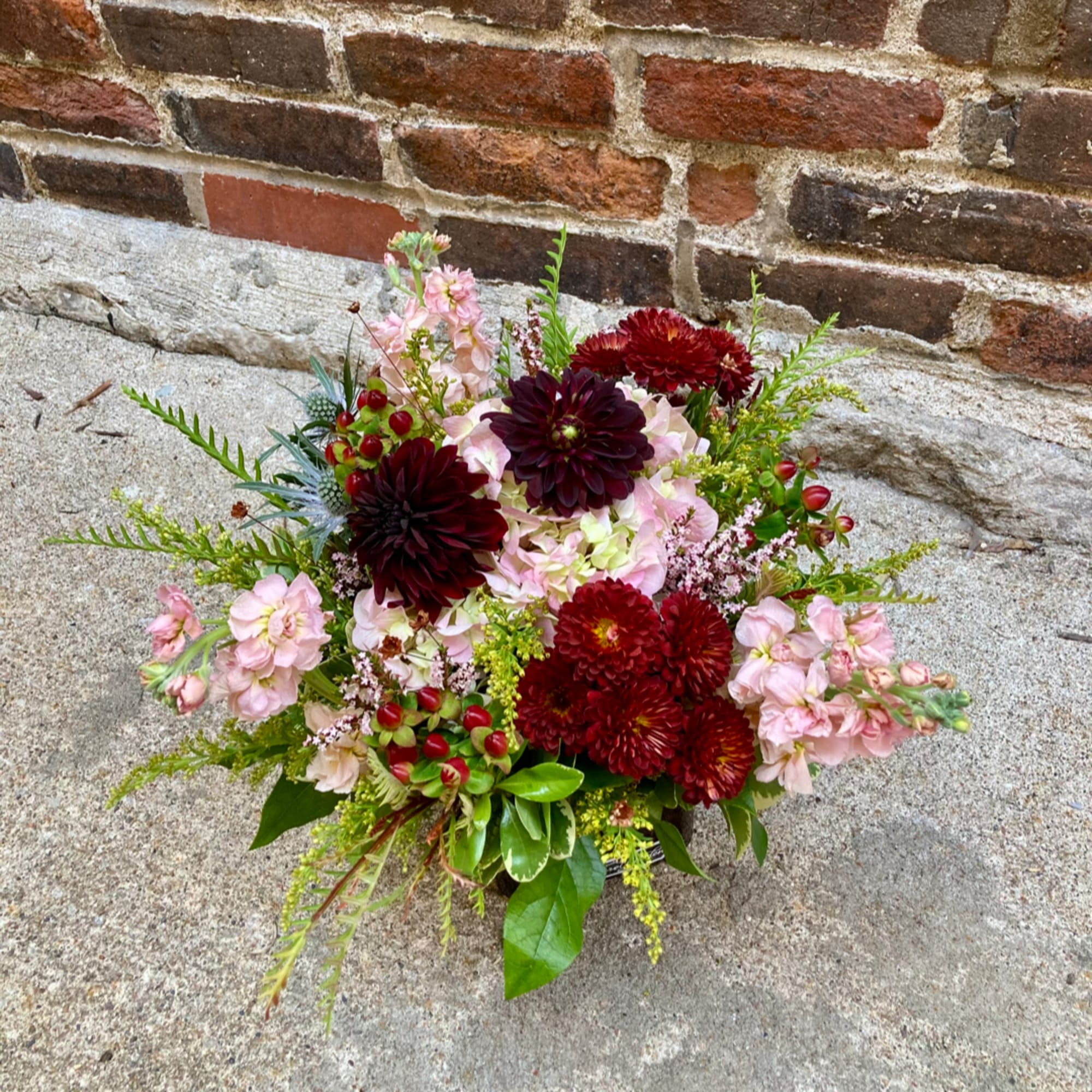 Mixed bouquet with burgundy and pink flowers in a low arrangement