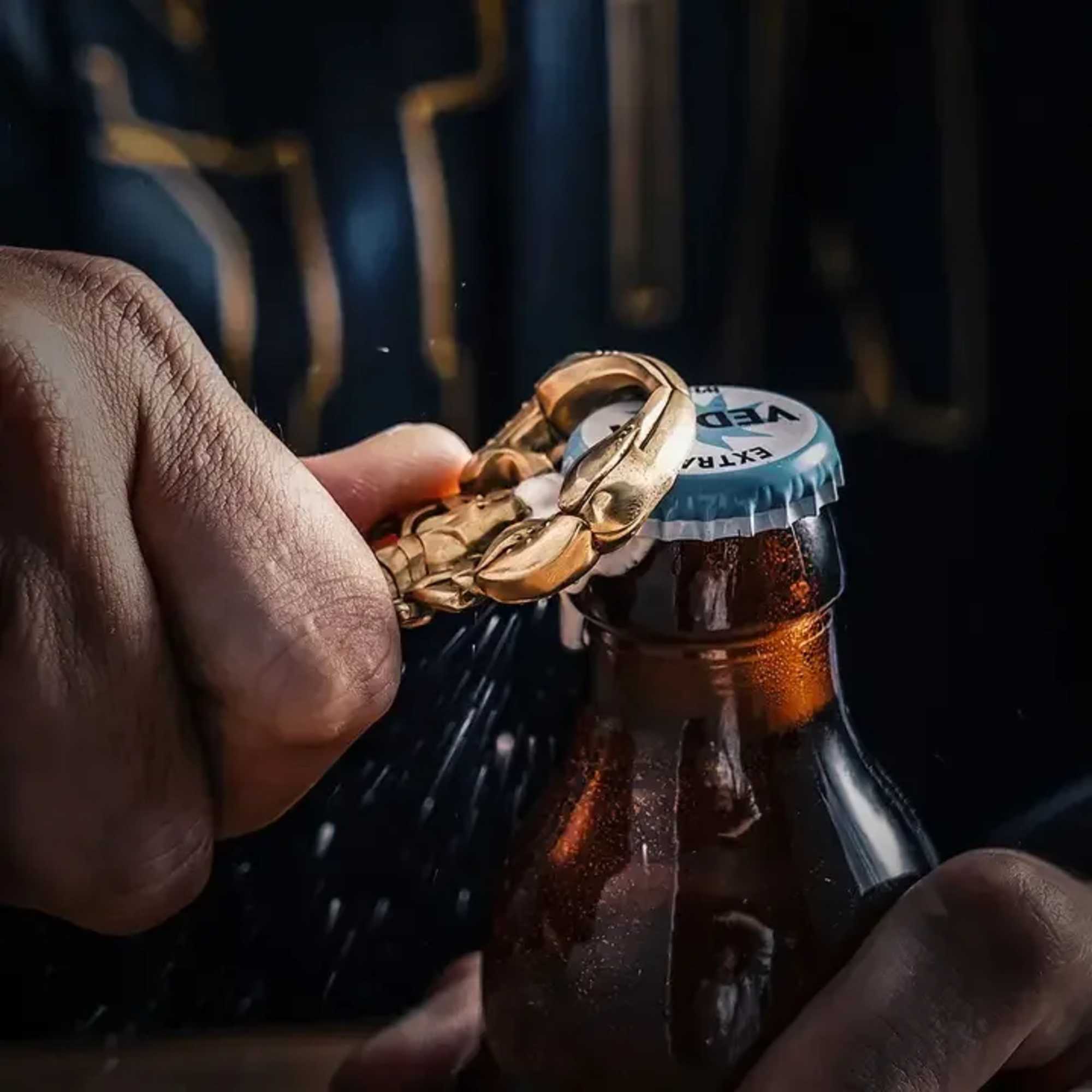 Hands opening a bottle with a gold chain around the cap