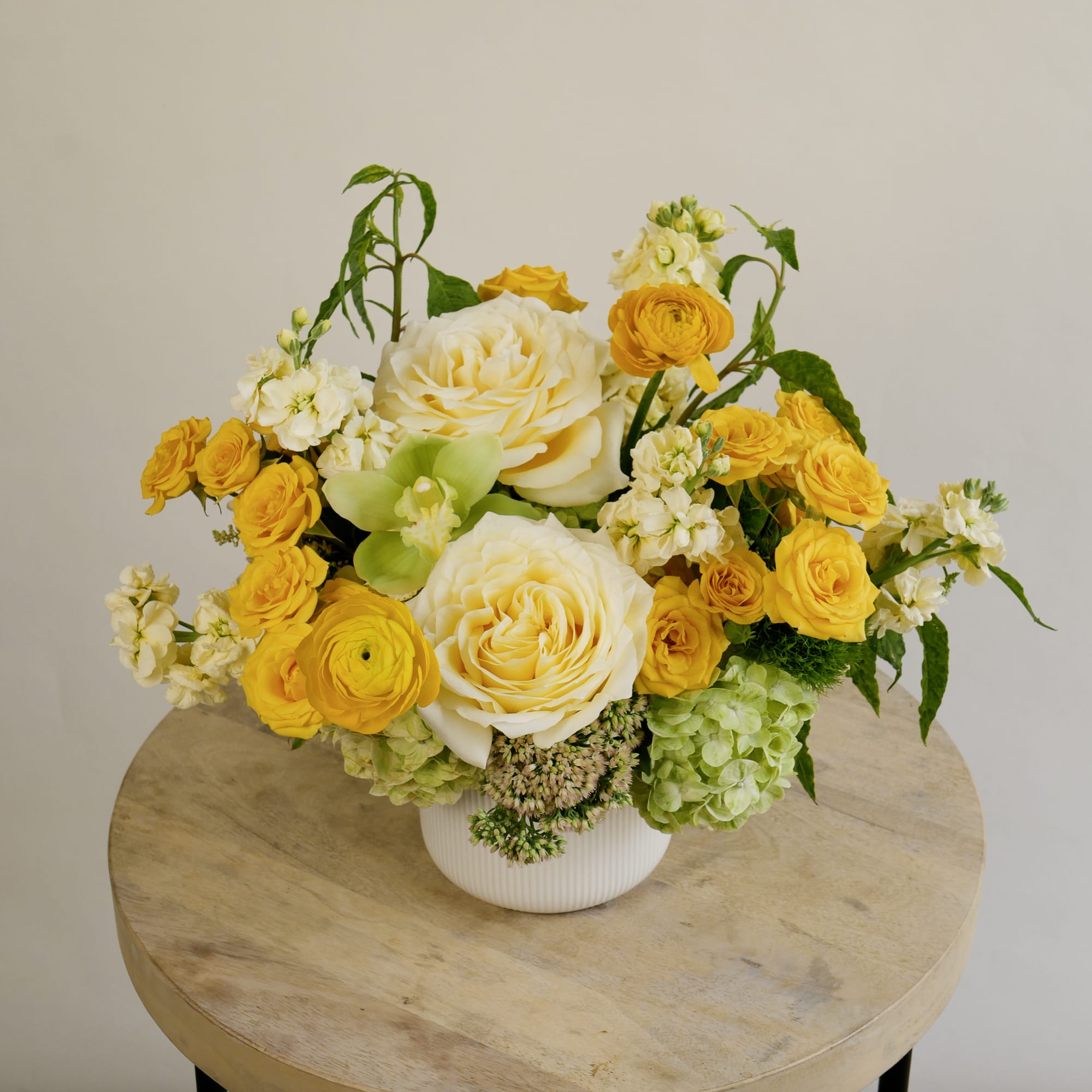 Yellow and white floral arrangement in a white vase