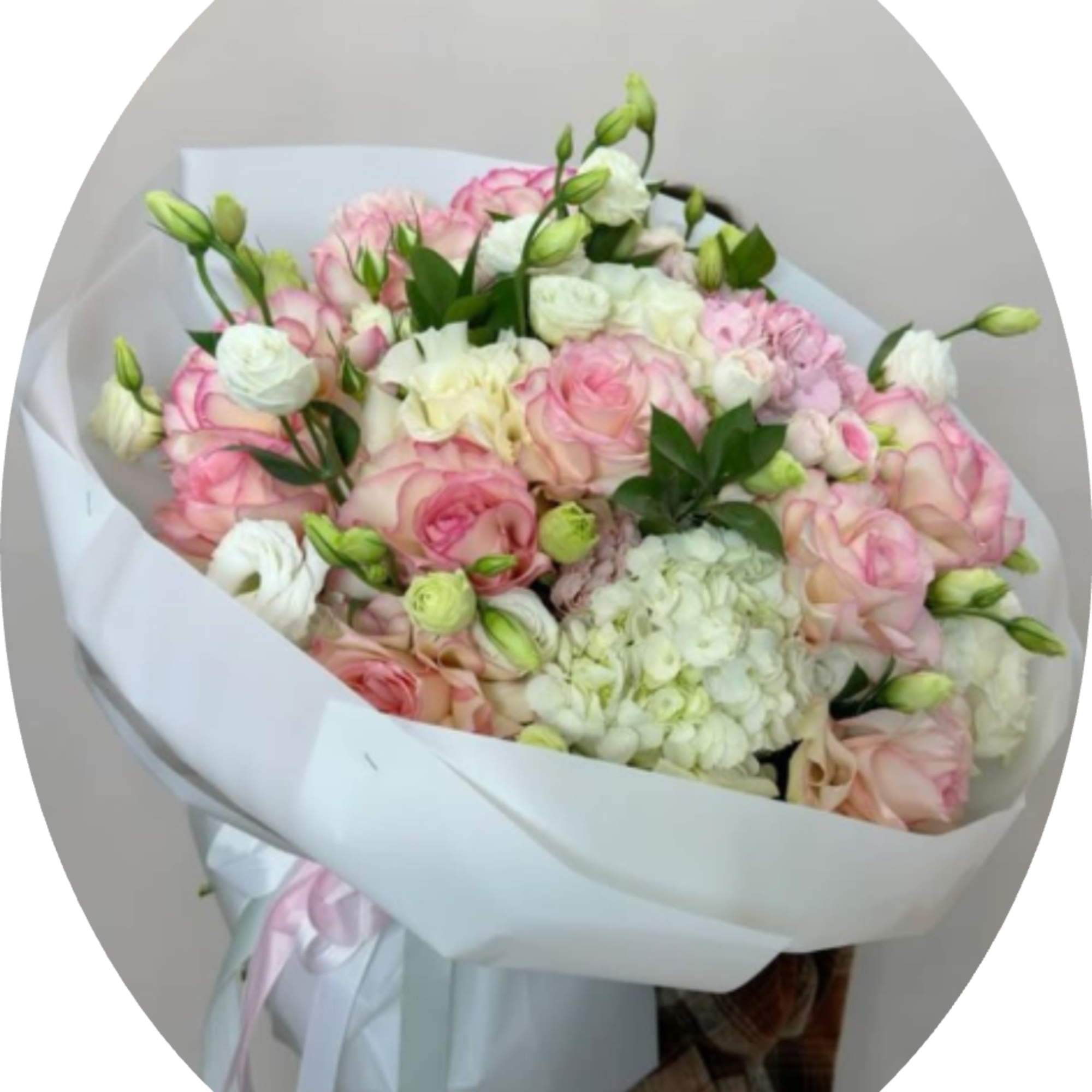 Soft pink and white roses gathered around a generous white hydrangea create