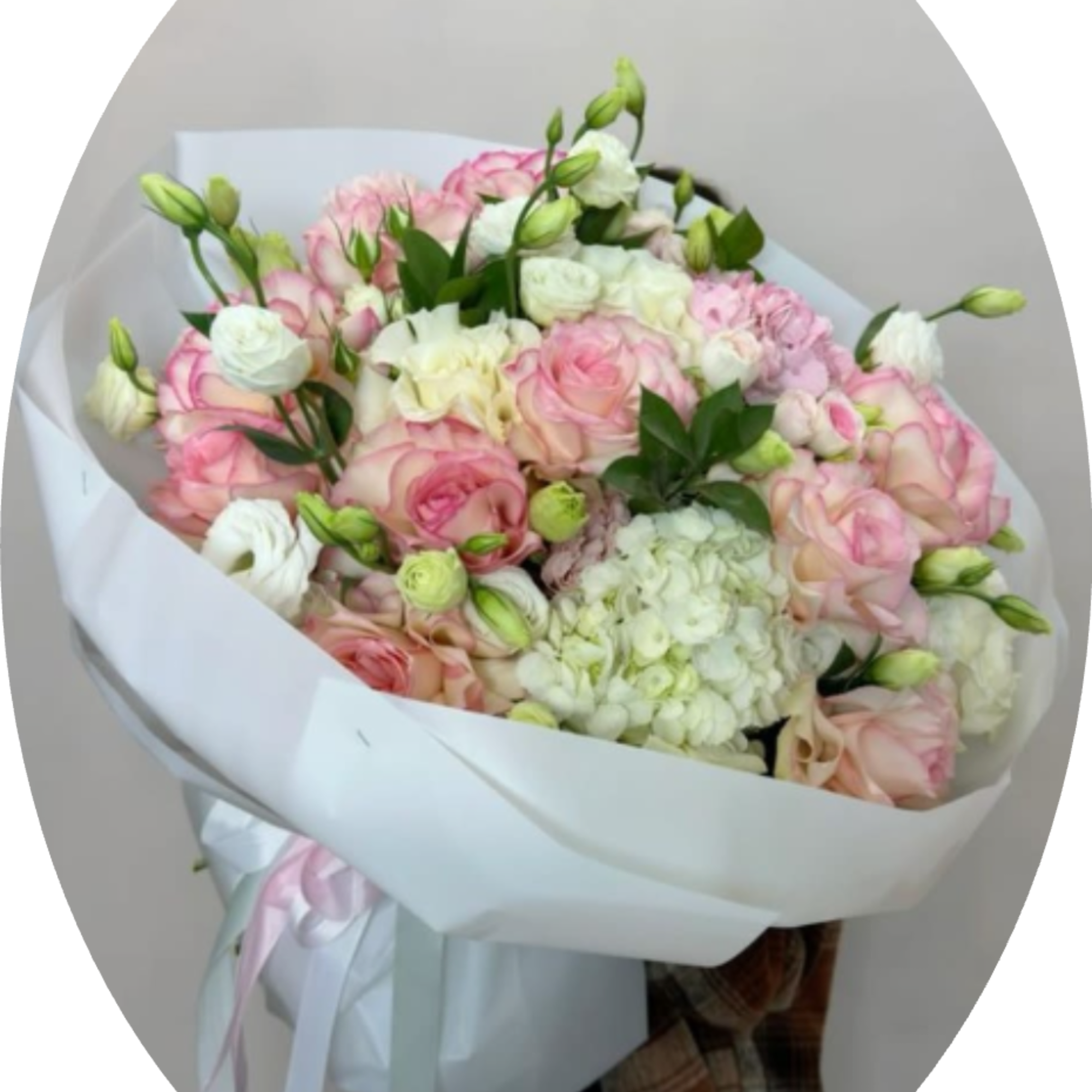 Soft pink and white roses gathered around a generous white hydrangea create