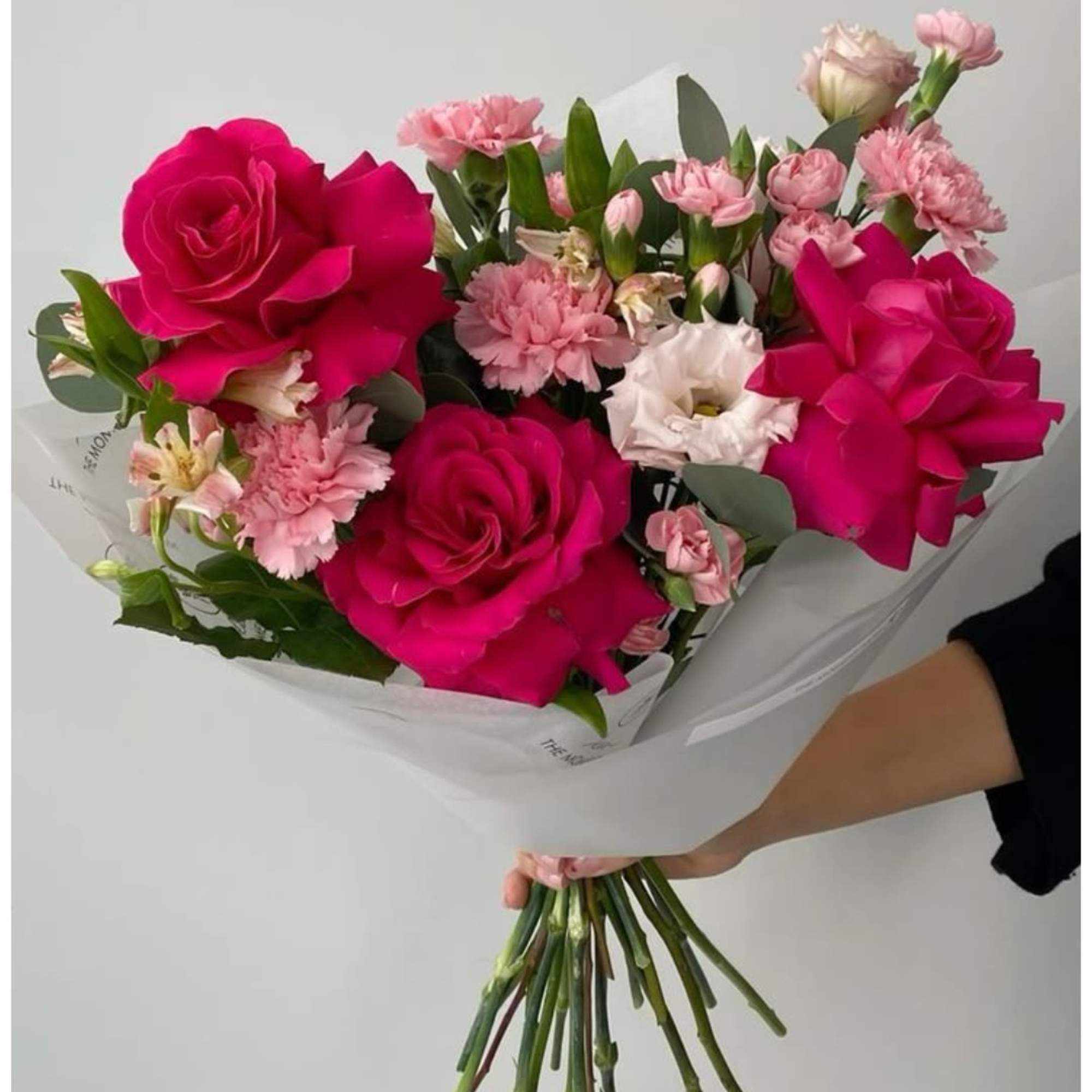Large hot pink roses steal the show in this birthday bouquet, their