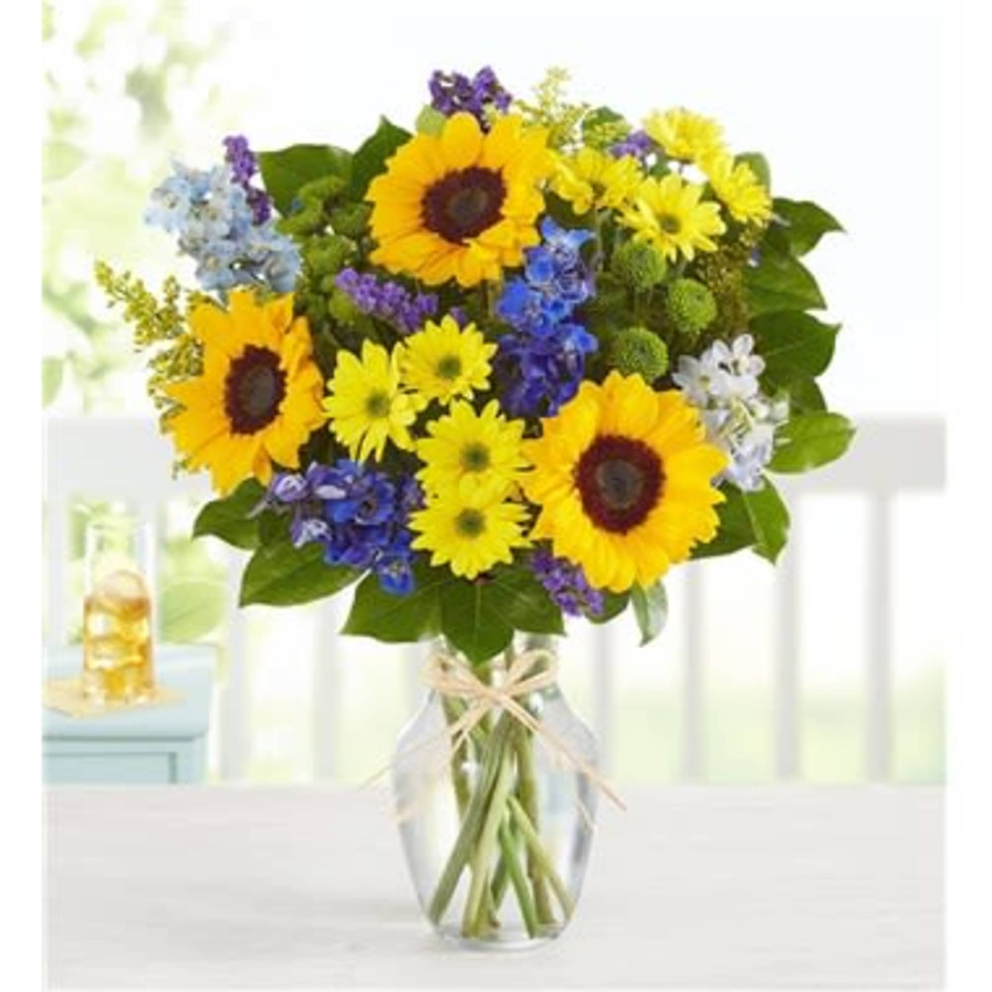 Bouquet of sunflowers and mixed blue and yellow flowers in a glass vase, photo 2 of 2