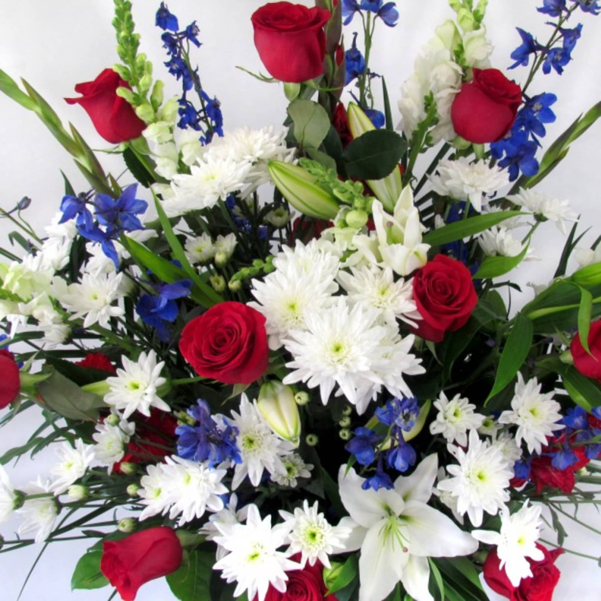Bouquet of red roses, white lilies, and blue flowers