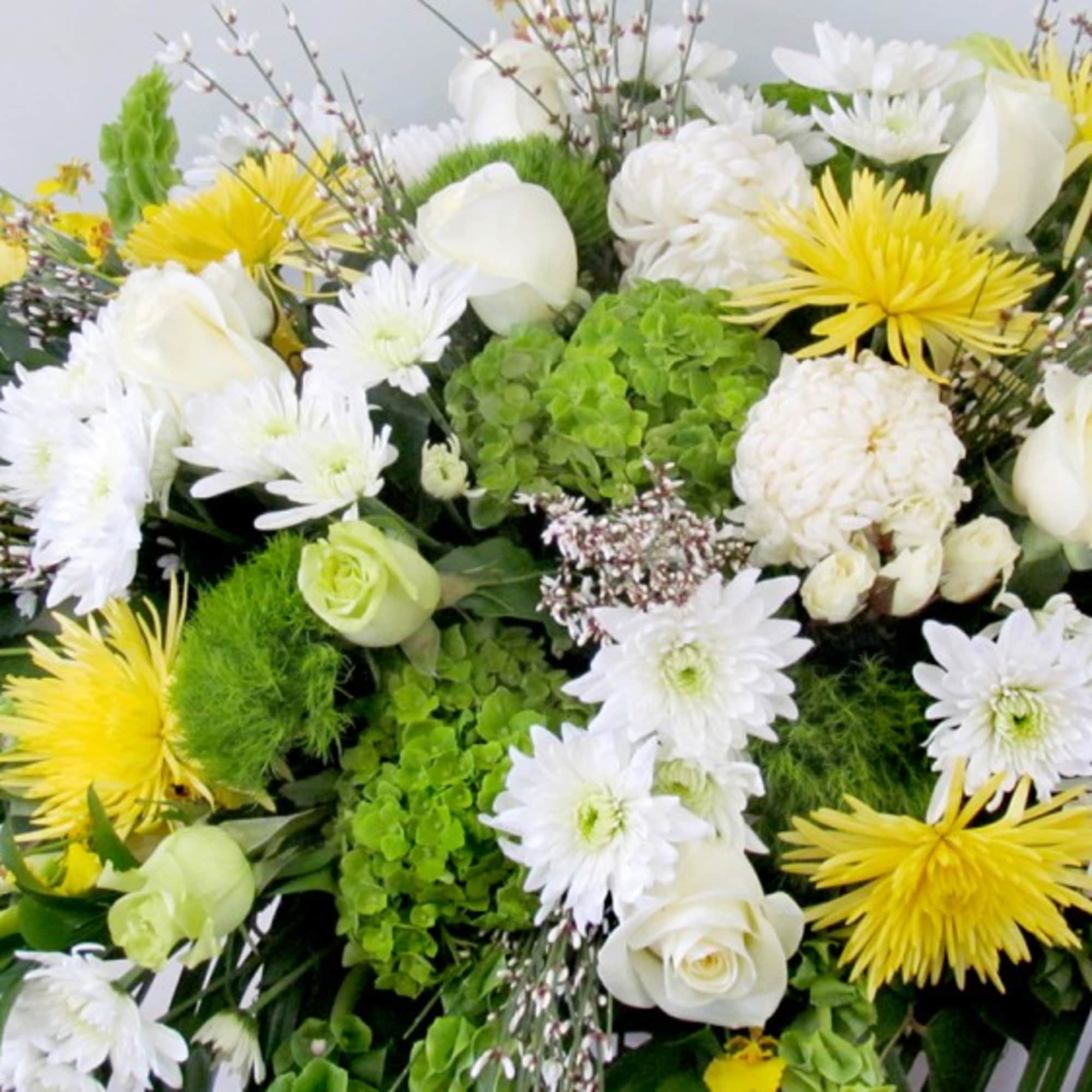 White and yellow floral arrangement with roses and daisies